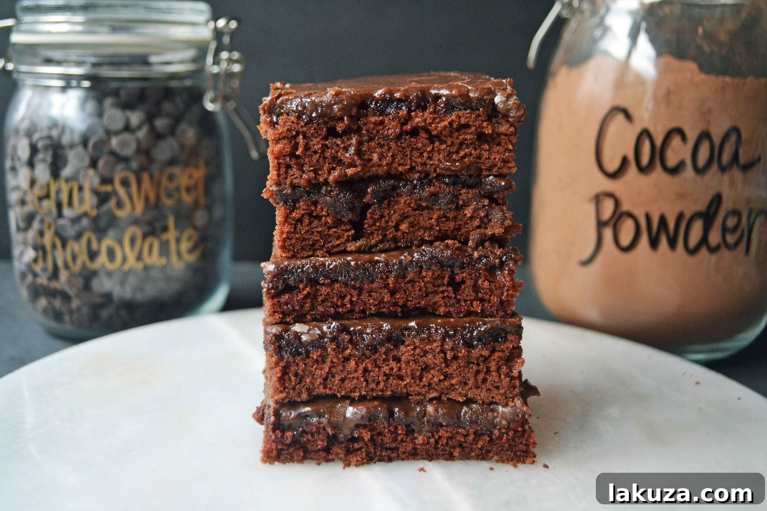 A close-up shot of a square of Best Dang Chocolate Texas Sheet Cake, showcasing the rich, dark chocolate cake and smooth, glossy frosting.