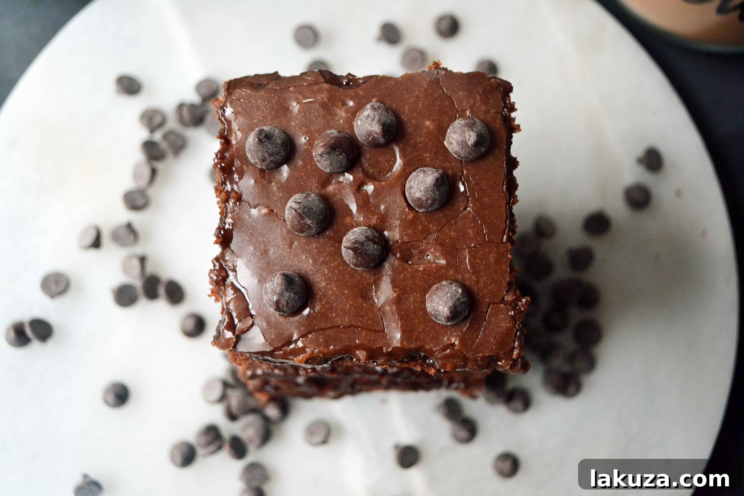 A close-up of a large piece of Texas Sheet Cake with a generous layer of smooth chocolate frosting, ready to be served.