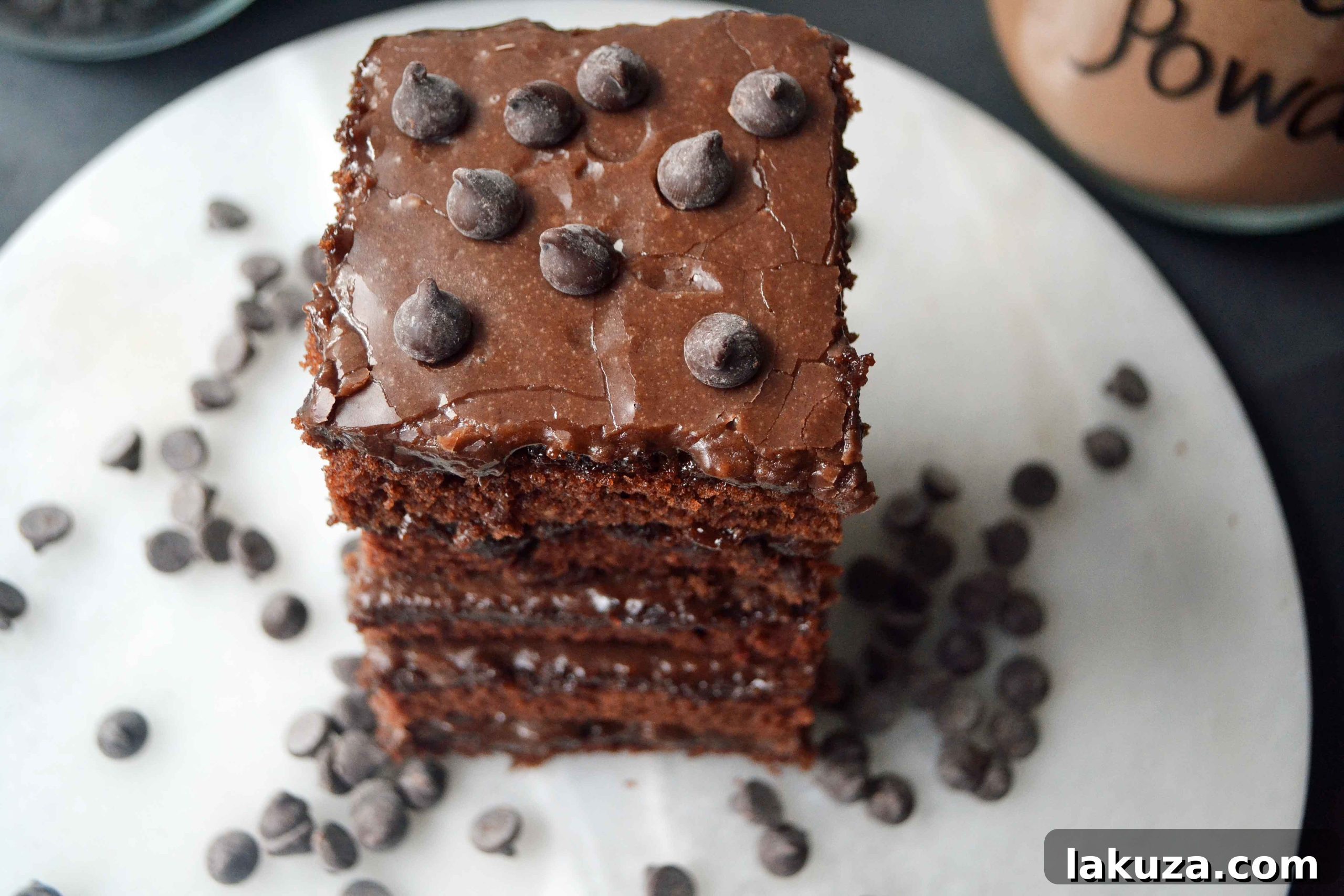 A delicious piece of Best Dang Chocolate Texas Sheet Cake, garnished with chocolate shavings and ready for dessert.