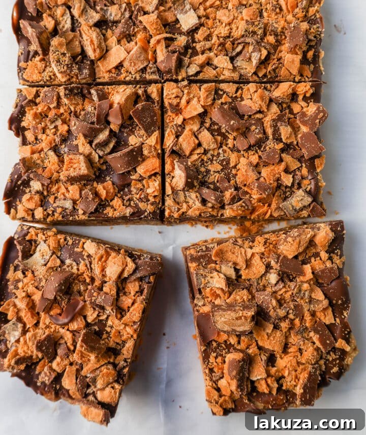 Ultimate Butterfinger Crunch Bars 6 A close-up of a single Crunchy Butterfinger Bar, showcasing its layers and appealing texture, ready to be picked up and enjoyed.