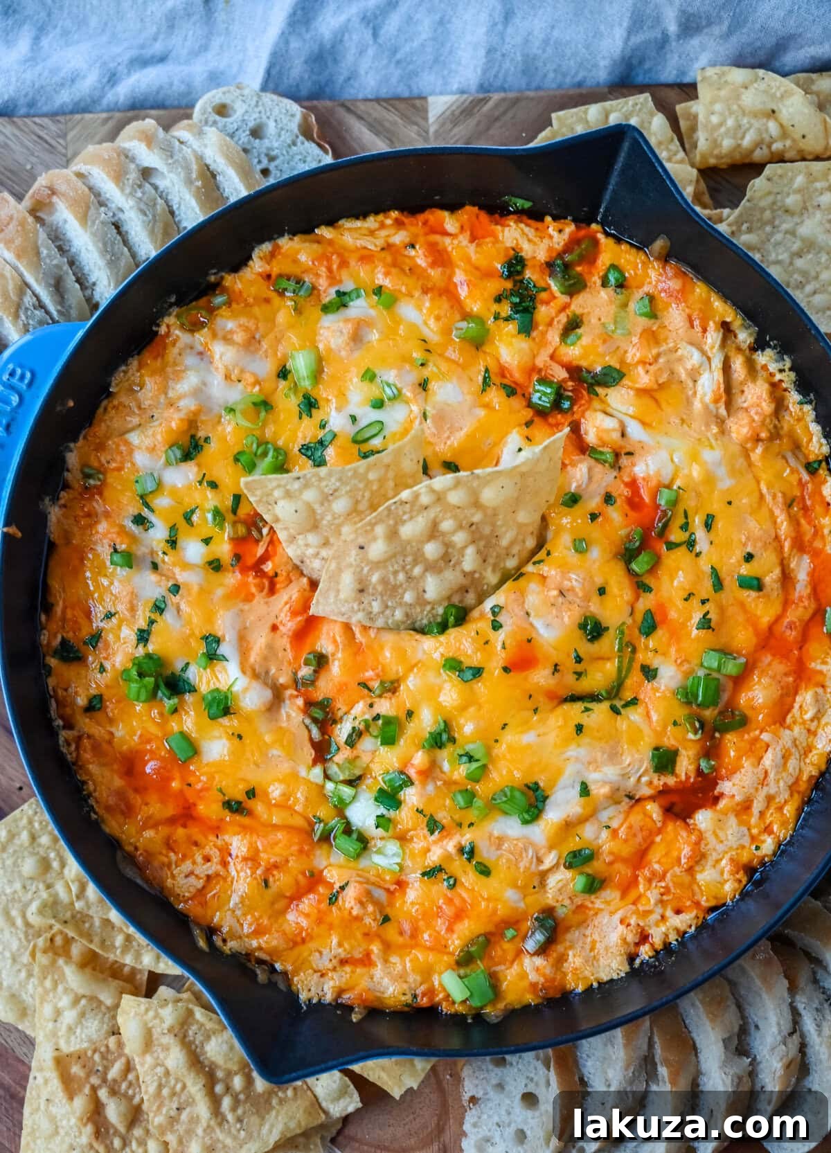 This Hot Creamy Buffalo Chip Dip is made with tender shredded chicken, cream cheese, buffalo sauce, ranch dressing, and topped with cheese, and baked until warm and bubbly. This is a perfect Super Bowl appetizer and this Chicken Hot Wing Dip is always a hit!