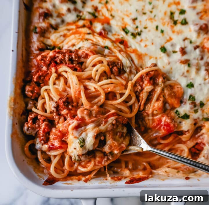 TikTok's Million-Dollar Baked Spaghetti Sensation 3 Close-up of baked spaghetti layers with meat sauce, Alfredo, and mozzarella