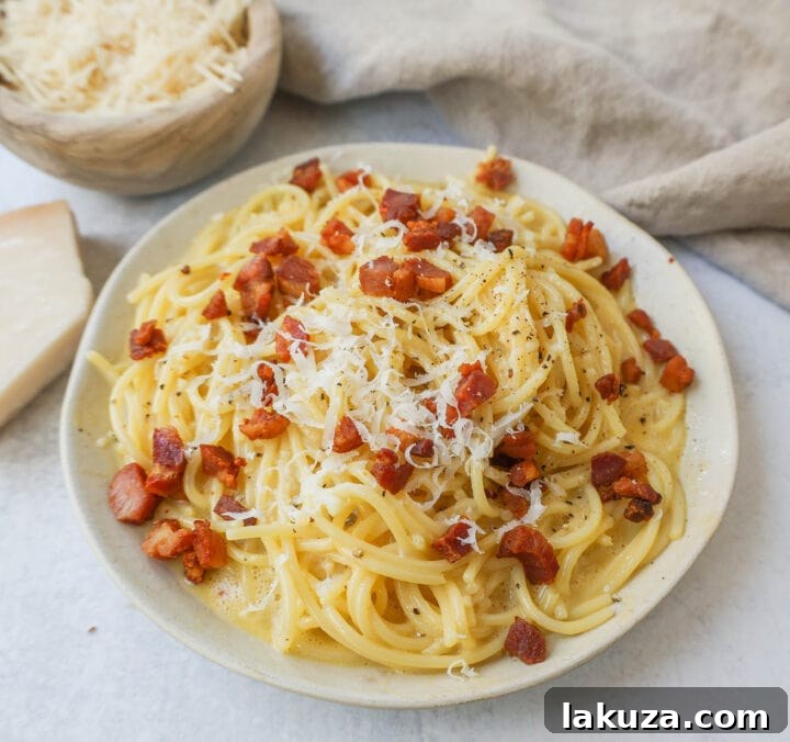 Crispy diced pancetta sizzling in a pan, releasing its savory fats, a crucial first step in preparing authentic spaghetti carbonara.
