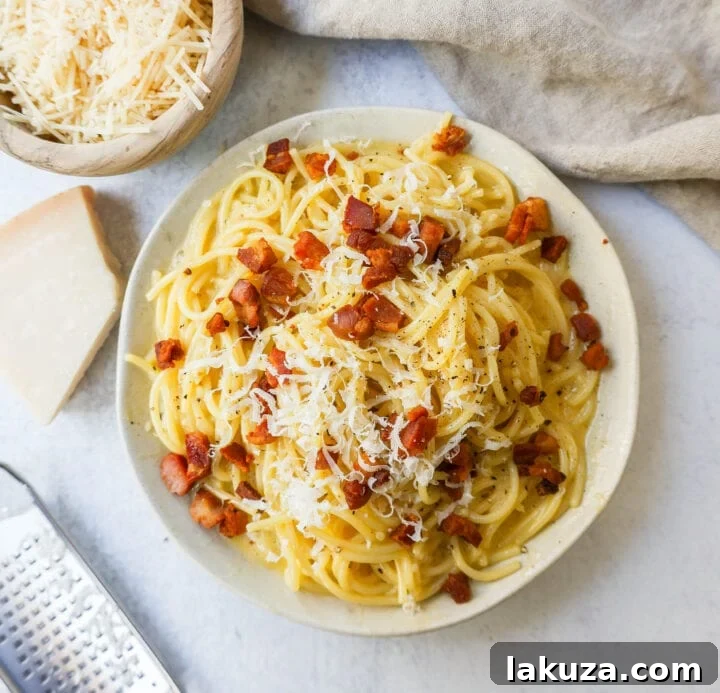 A close-up of a generous pile of freshly grated Parmigiano Reggiano cheese, essential for creating the rich and savory sauce of an authentic carbonara.