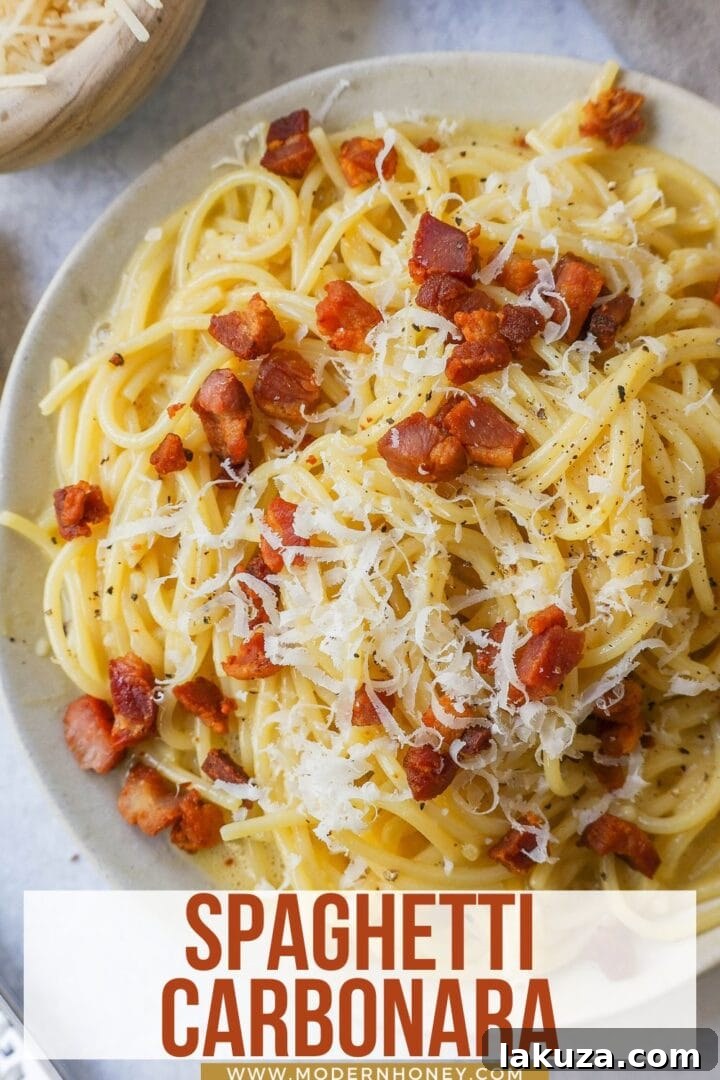 A beautifully presented serving of spaghetti carbonara in a deep bowl, topped with extra black pepper and cheese, reflecting its simple elegance.