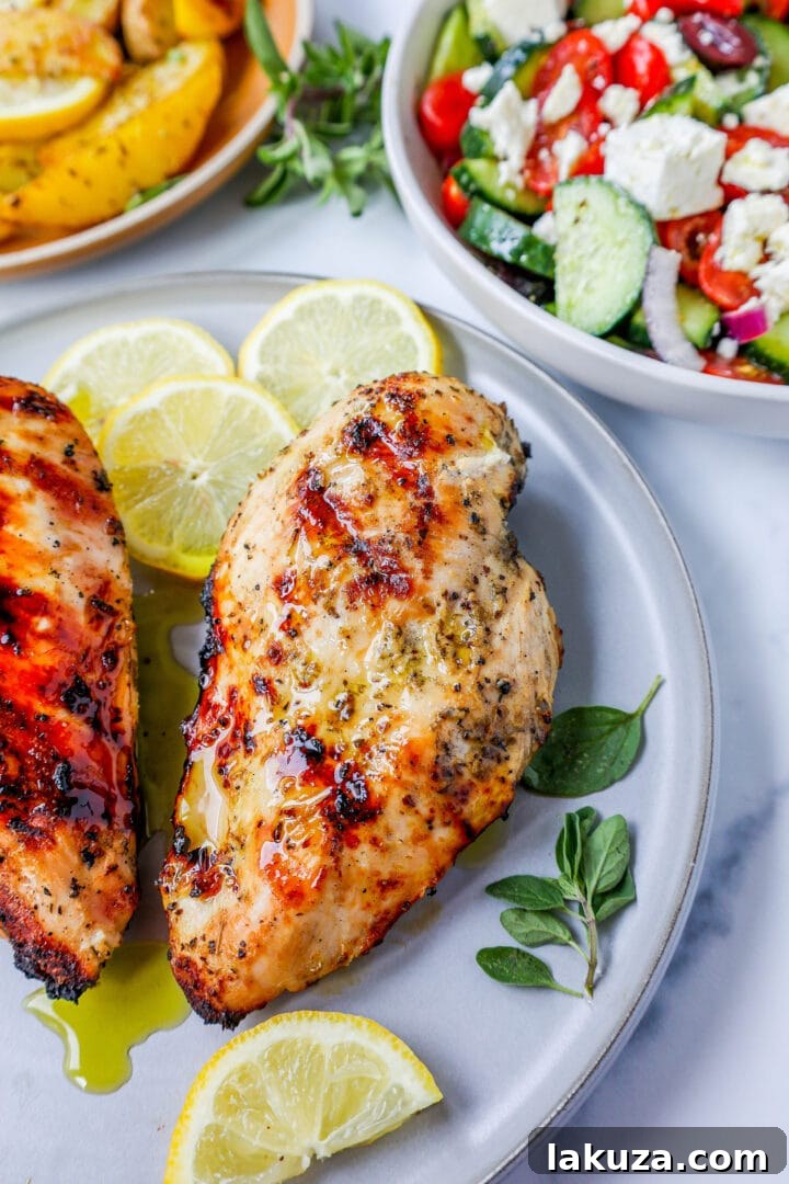 Juicy, tender grilled Greek chicken breasts marinated in olive oil, lemon, garlic, and oregano, served with fresh herbs.