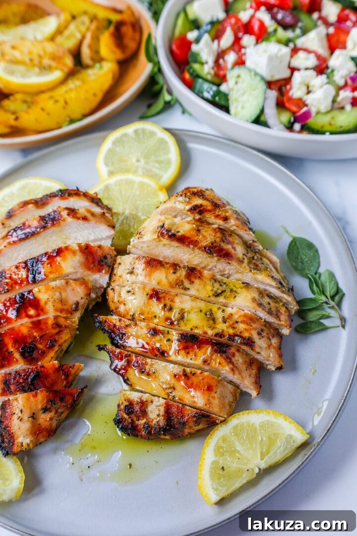 A vibrant platter of freshly grilled Greek chicken, accompanied by various side dishes like roasted potatoes and salads, ready to be enjoyed.