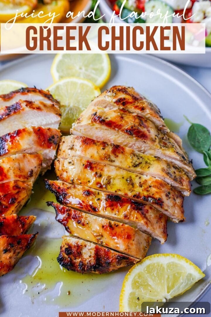 A close-up shot of a perfectly grilled Greek chicken breast, garnished with fresh oregano and lemon wedges, ready to be served.