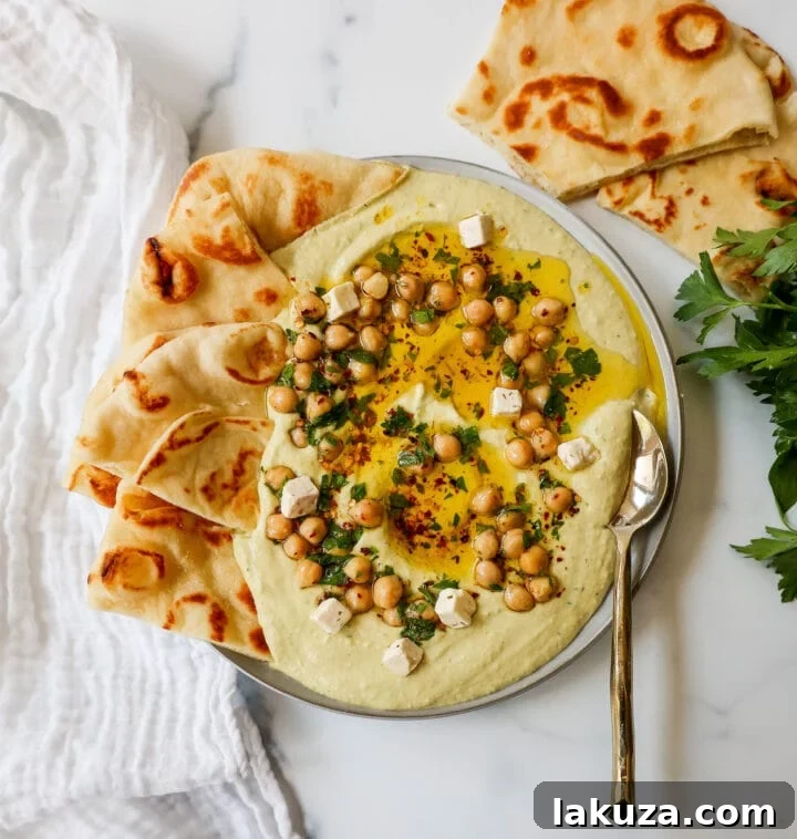 Golden Chickpea Perfection 3 Close-up of freshly made creamy homemade hummus garnished with a swirl of olive oil, chickpeas, and a sprinkle of paprika.