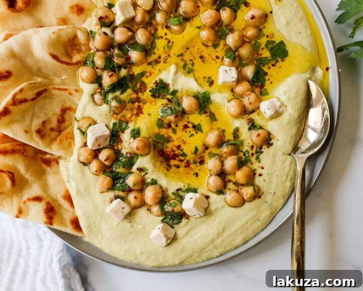 Golden Chickpea Perfection 5 A vibrant platter of homemade hummus served with fresh vegetables, pita bread, and other Mediterranean appetizers.