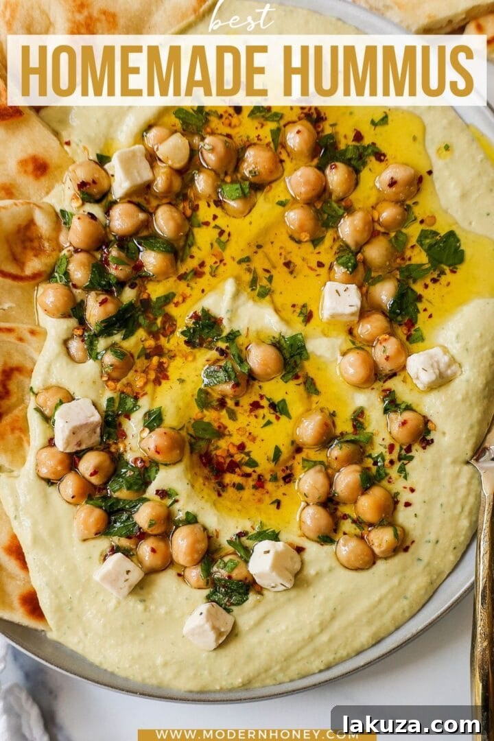Golden Chickpea Perfection 7 A large serving of creamy homemade hummus, richly garnished with olive oil and herbs, ready to be enjoyed.
