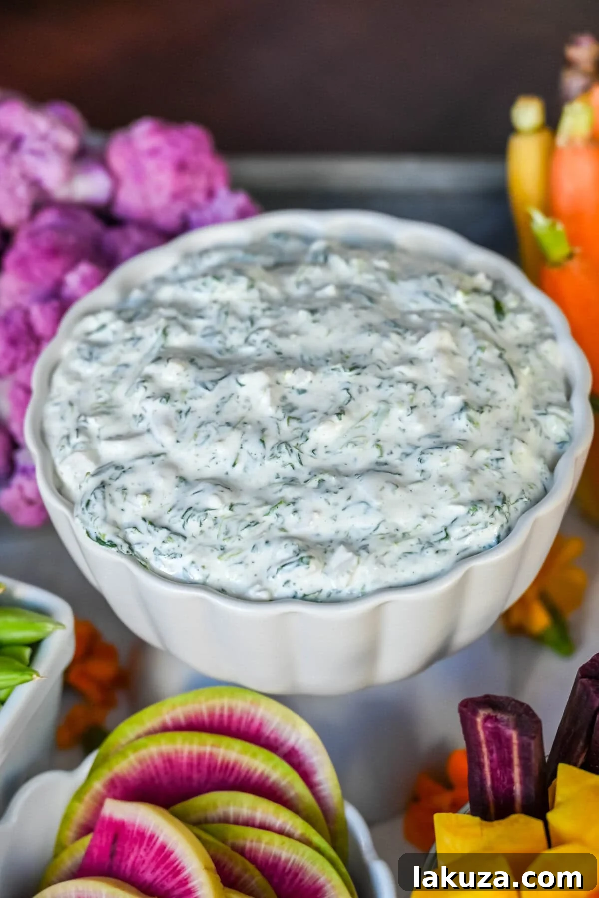 Homemade cold spinach dip on a crudite platter or vegetable board