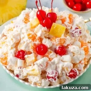 The Best Ambrosia Salad is a fluffy salad made with fresh pineapple, mandarin oranges, maraschino cherries, coconut, marshmallows, fresh whipped cream, a touch of sour cream, and sugar. This is a nostalgic, classic side dish or dessert recipe.