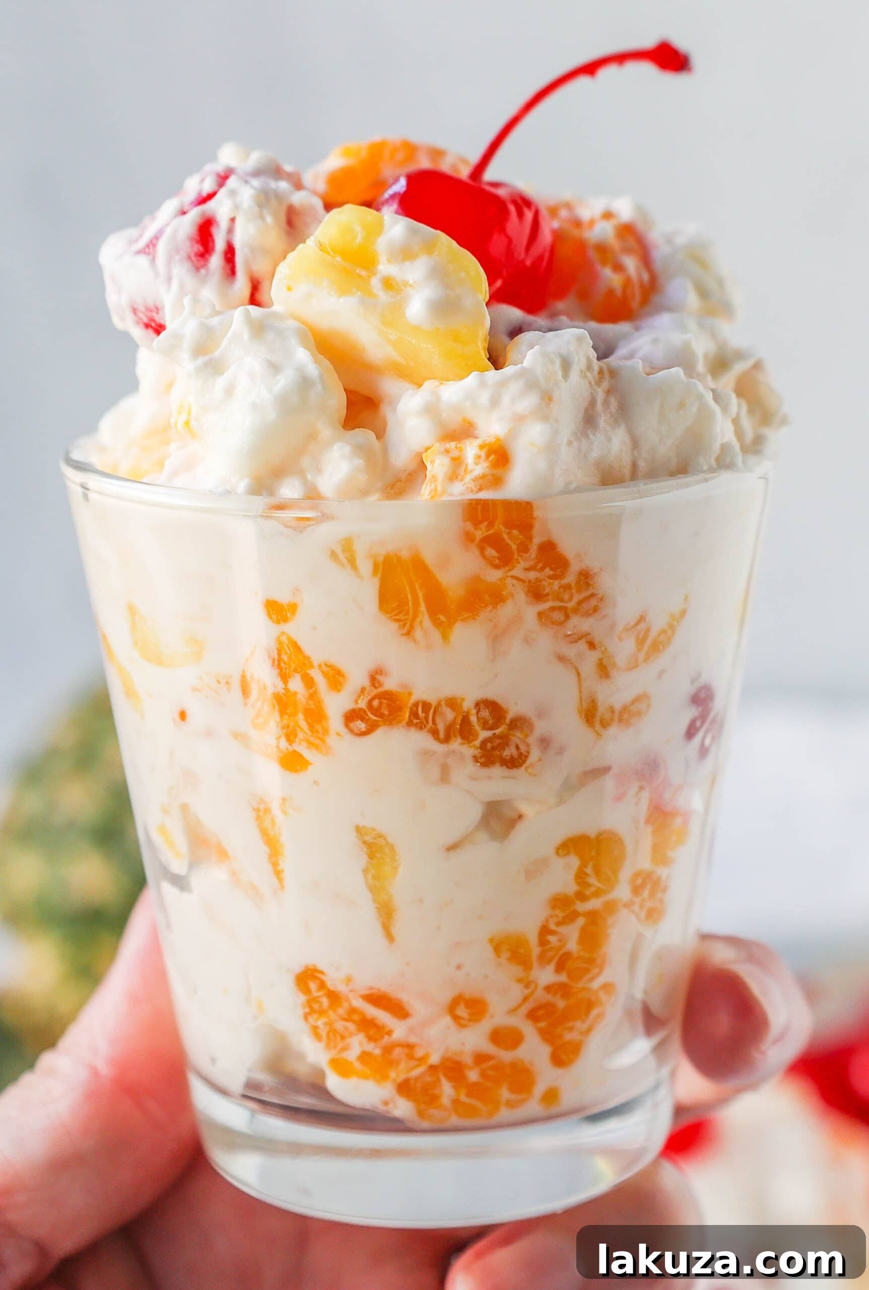 Sweet Ambrosia Cloud 4 A vibrant bowl of Ambrosia Salad with fresh whipped cream, showcasing its fluffy texture and colorful fruits. Perfect for holiday tables and special occasions.
