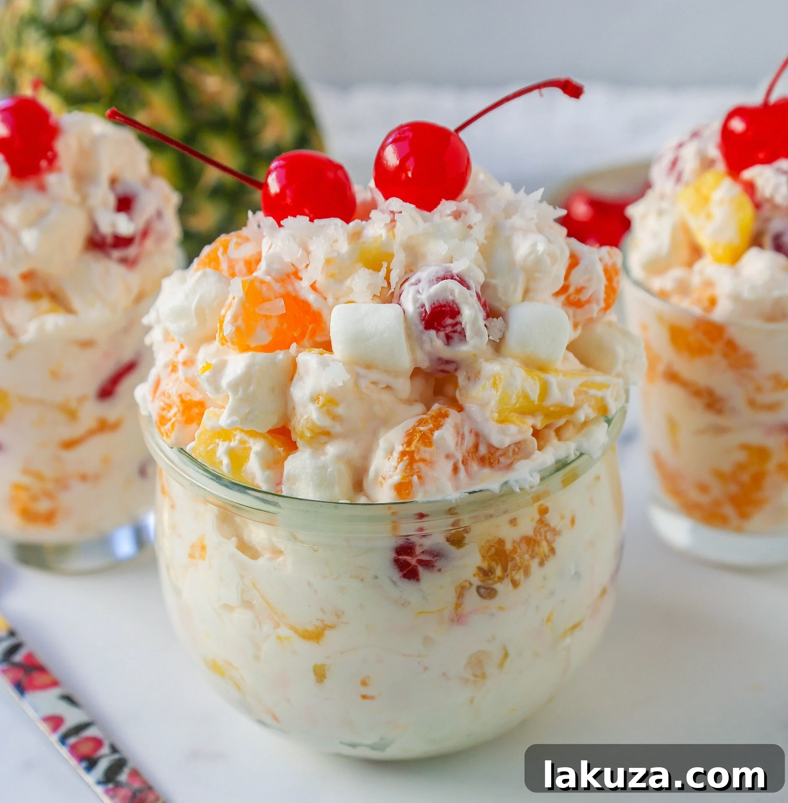 Sweet Ambrosia Cloud 7 A bowl of Ambrosia Salad ready to be served, garnished with fresh fruit and coconut. Ideal for spring and summer gatherings.