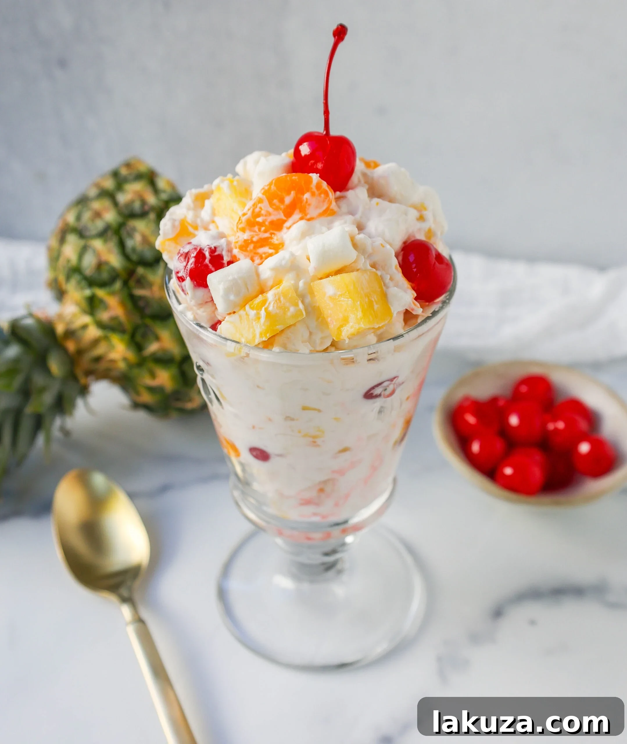 Sweet Ambrosia Cloud 9 Serving of Ambrosia Salad in a small glass bowl, garnished with a cherry. A delightful individual portion of this classic dessert.