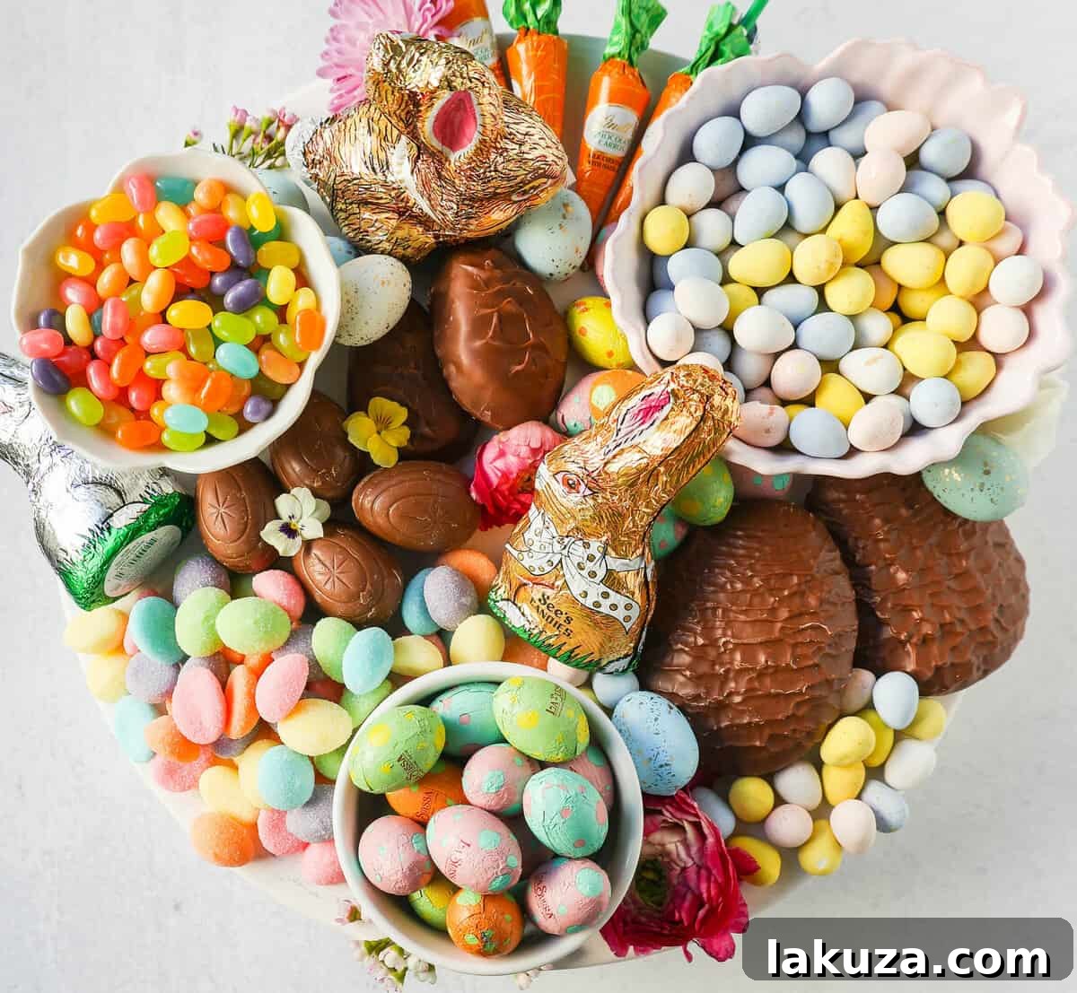 An Easter dessert board featuring a variety of chocolate eggs, bunny-shaped candies, and colorful jelly beans, ready for serving.