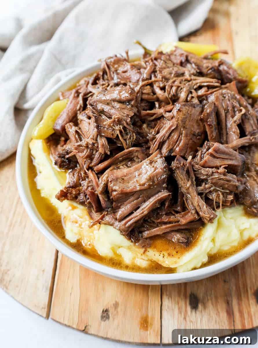 A bowl of shredded Mississippi Pot Roast with gravy, ready to be enjoyed.