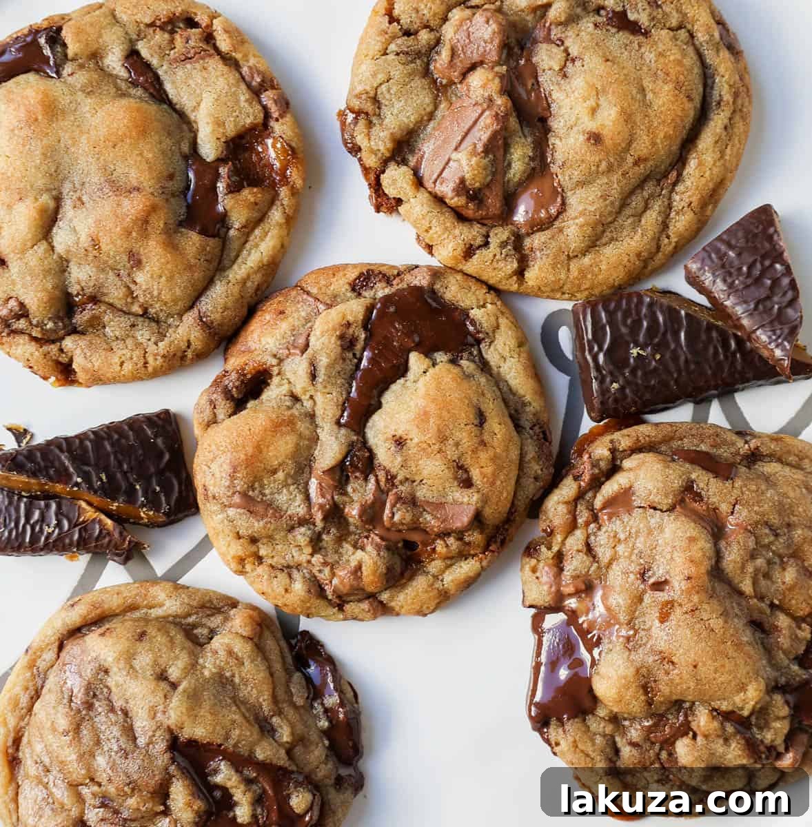 Caramelized Butter Toffee Chip Cookies 3 A stack of perfectly baked browned butter toffee chocolate chip cookies, showcasing their golden-brown edges and soft interiors.