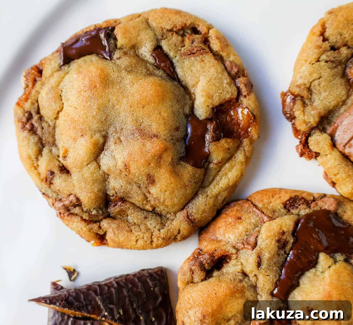 Caramelized Butter Toffee Chip Cookies 5 Close-up of a warm browned butter toffee chocolate chip cookie with melting chocolate and visible toffee pieces, fresh from the oven.