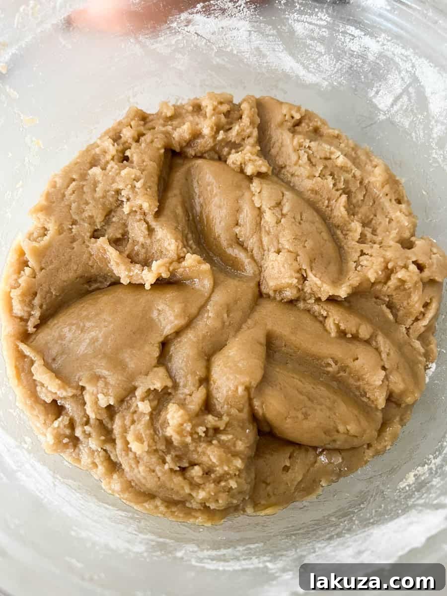 Caramelized Butter Toffee Chip Cookies 8 Adding flour, baking soda, and salt to the cookie dough mixture, ensuring it's not too warm before adding chocolate.