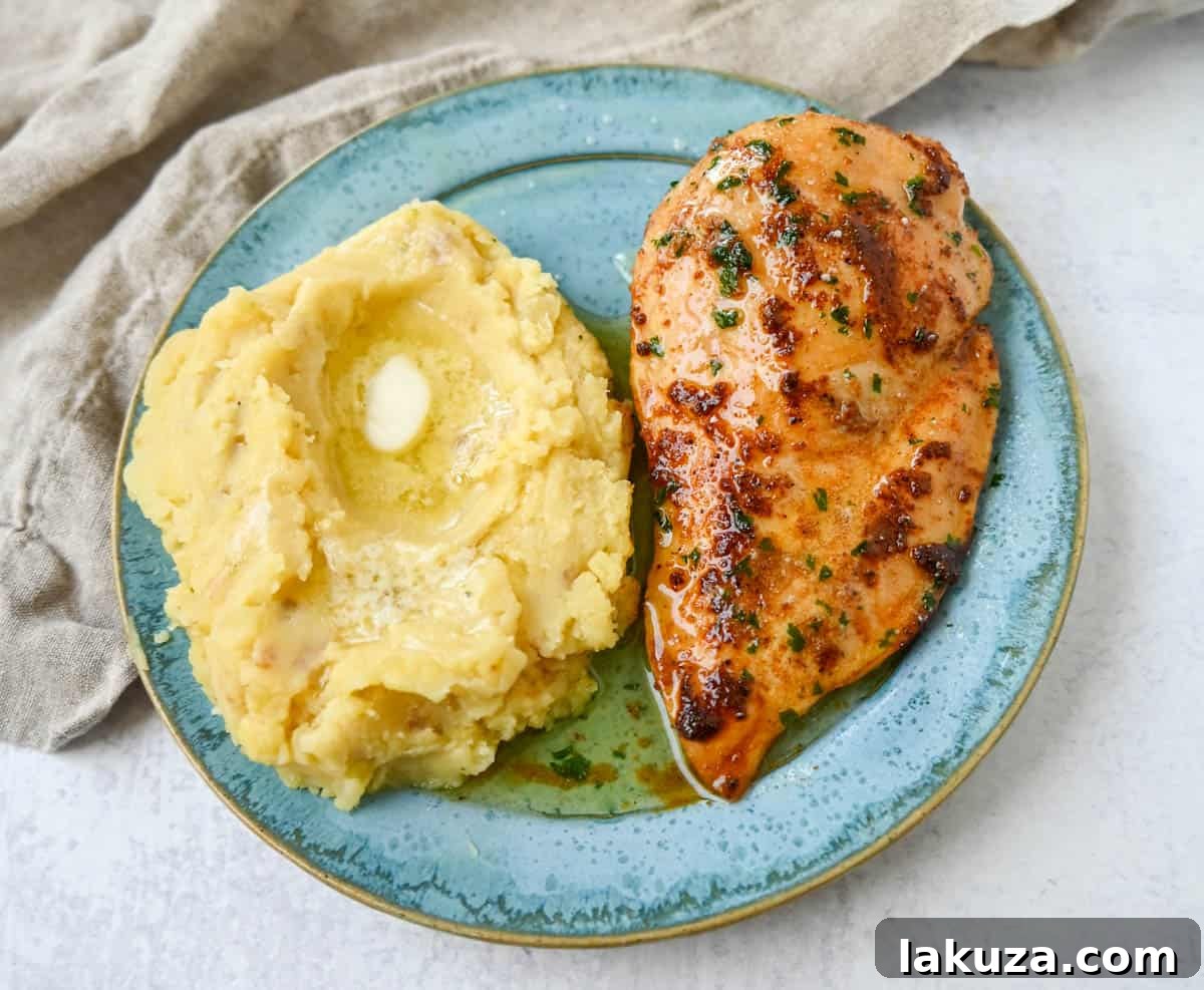 Sliced baked chicken revealing its juicy interior, garnished with fresh herbs.