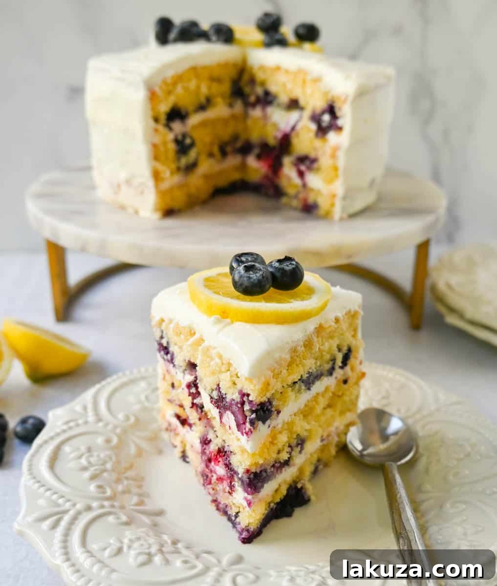 Close-up of a beautifully frosted lemon blueberry cake, garnished with fresh blueberries