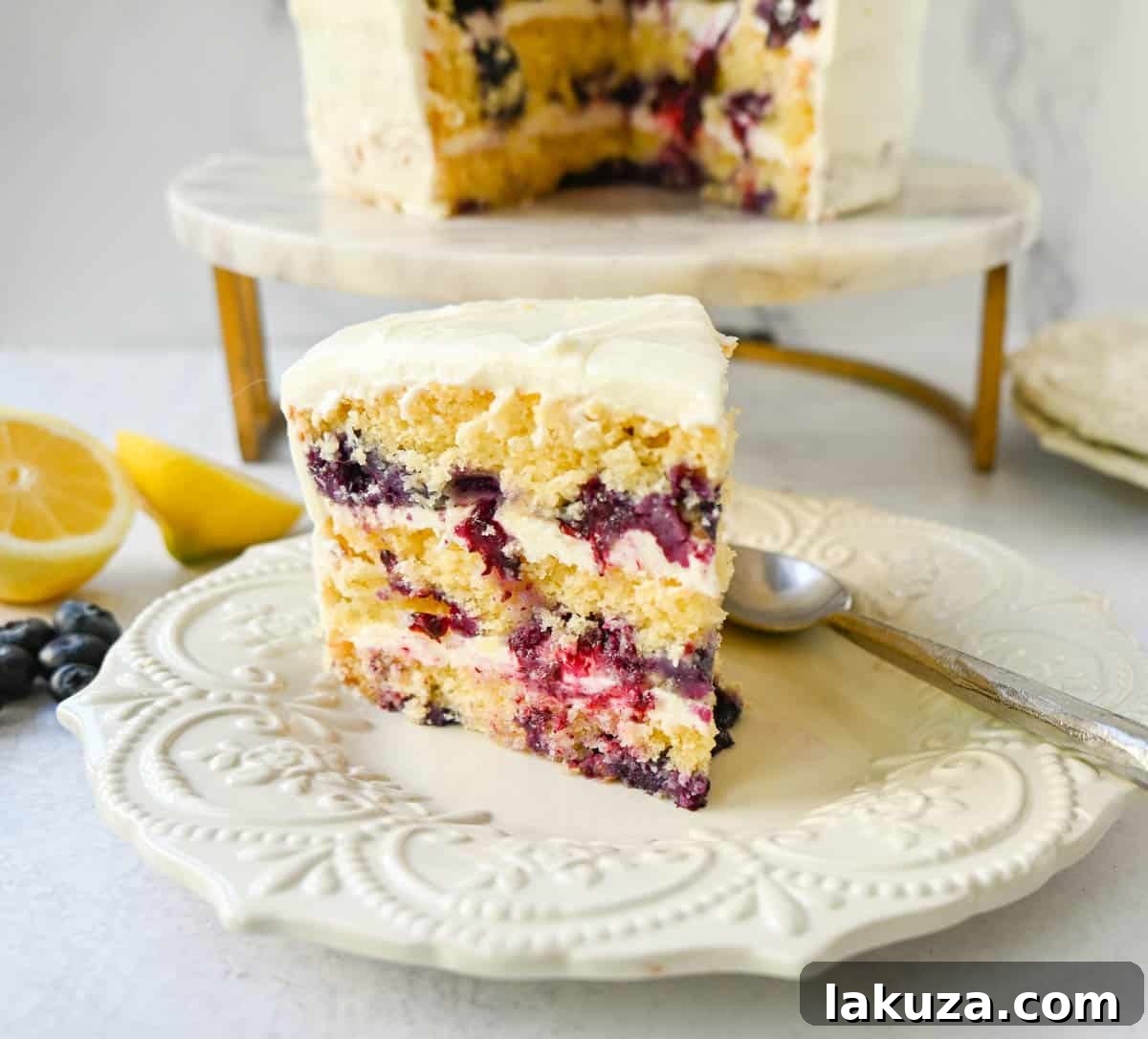 A whole lemon blueberry cake, showcasing its layers and rich cream cheese frosting