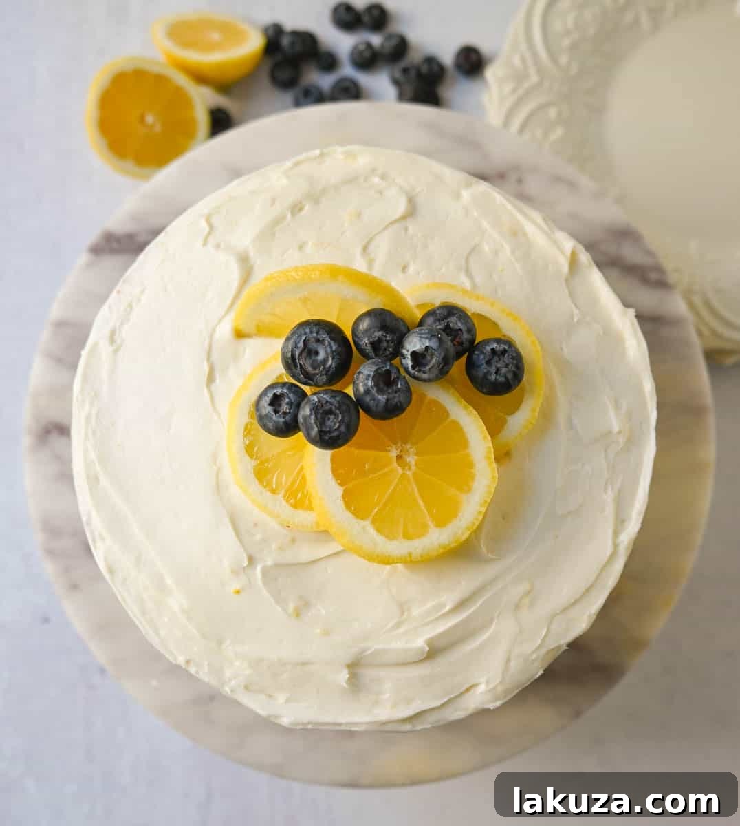Finished lemon blueberry cake, garnished with fresh blueberries and lemon slices