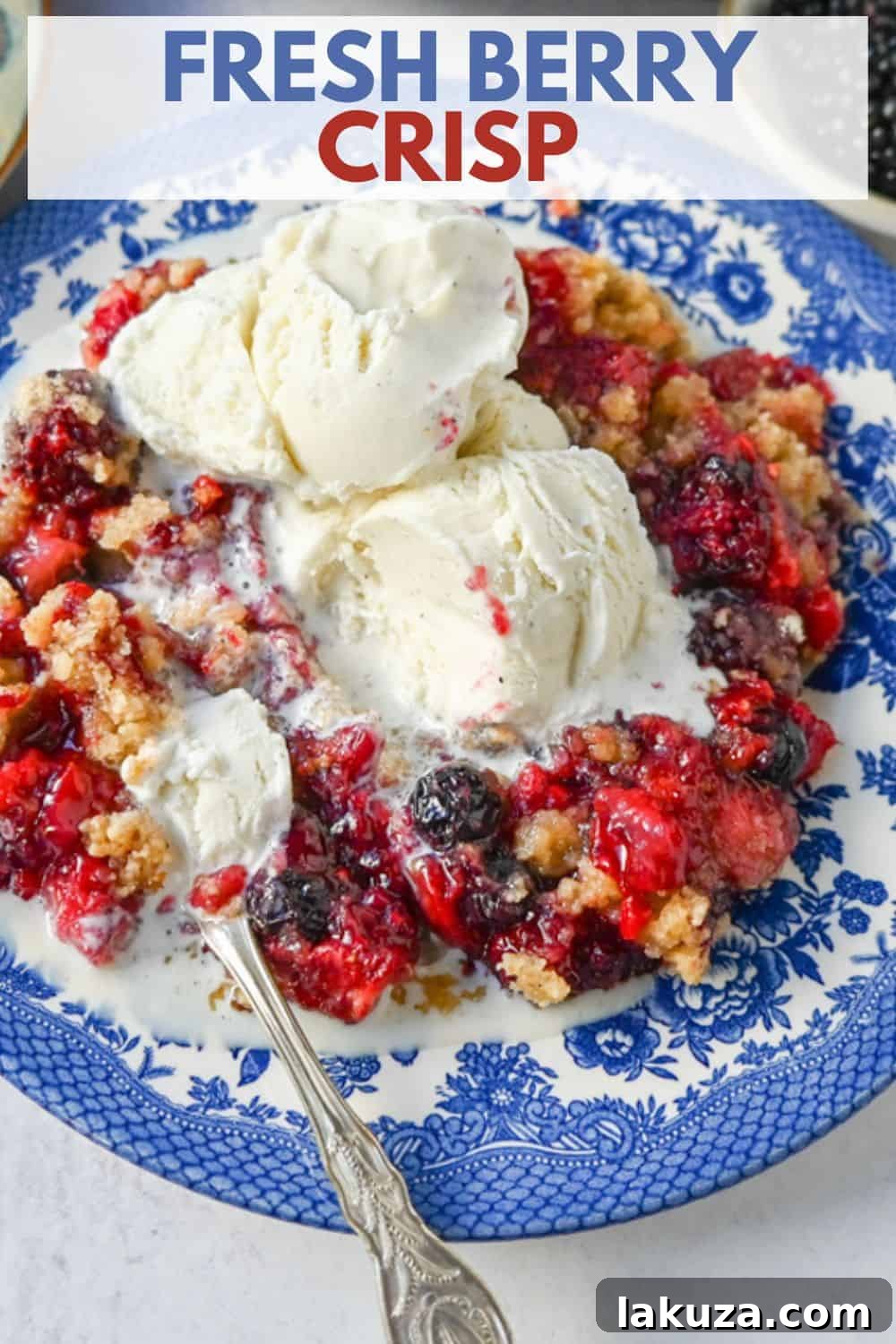 A serving of homemade Mixed Berry Crisp topped with melting vanilla ice cream in a white bowl, against a rustic wooden background, ready to be eaten.