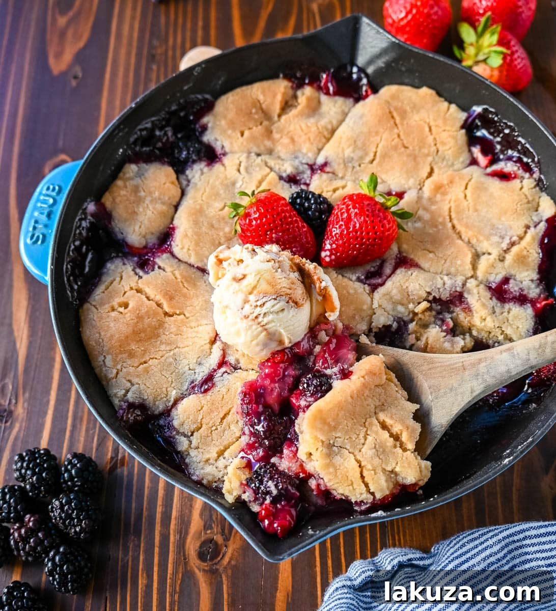 The homemade Mixed Berry Crisp baking in the oven, with the berries bubbling and the sugar cookie crumble topping turning golden brown and crispy.