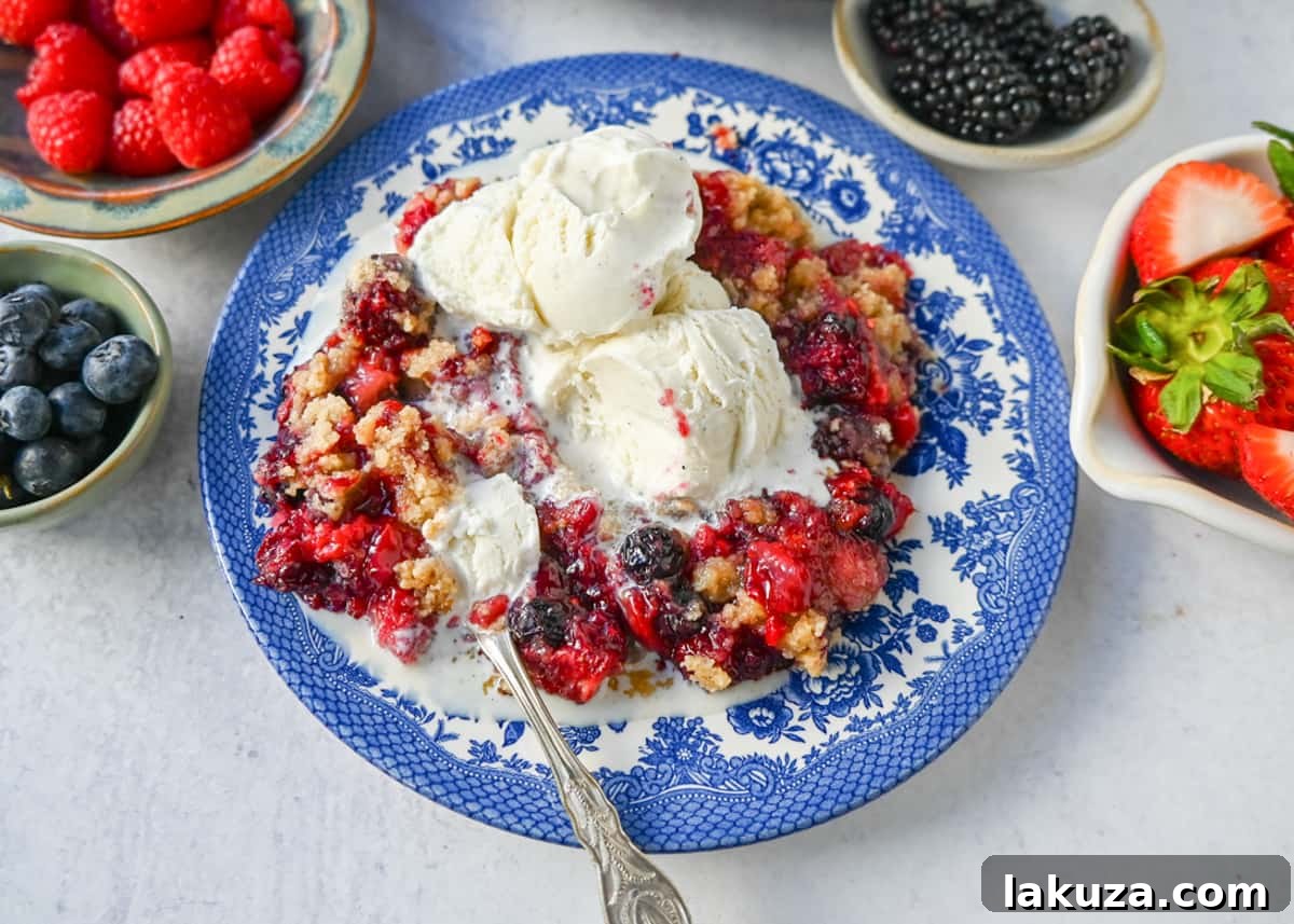 A freshly baked homemade Mixed Berry Crisp, golden and bubbling, served in a cast iron skillet with a scoop of vanilla bean ice cream on top, ready to be enjoyed.