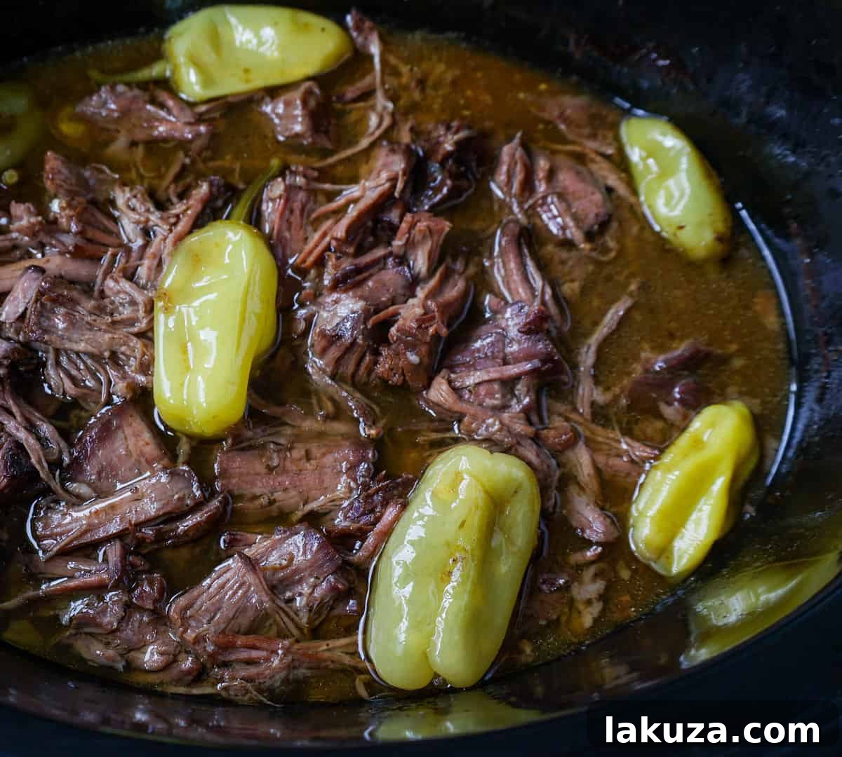 Boneless beef chuck roast searing in a hot skillet with oil, preparing for slow cooking.