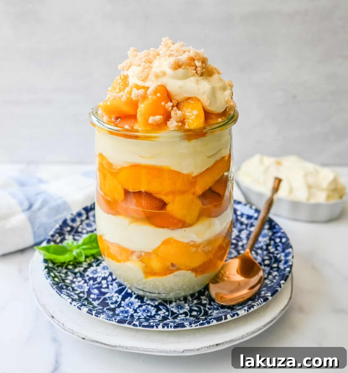 Layers of creamy vanilla pudding, fresh peaches, Nilla wafers, and buttery crumble in a Magnolia Bakery Peach Crisp Pudding.