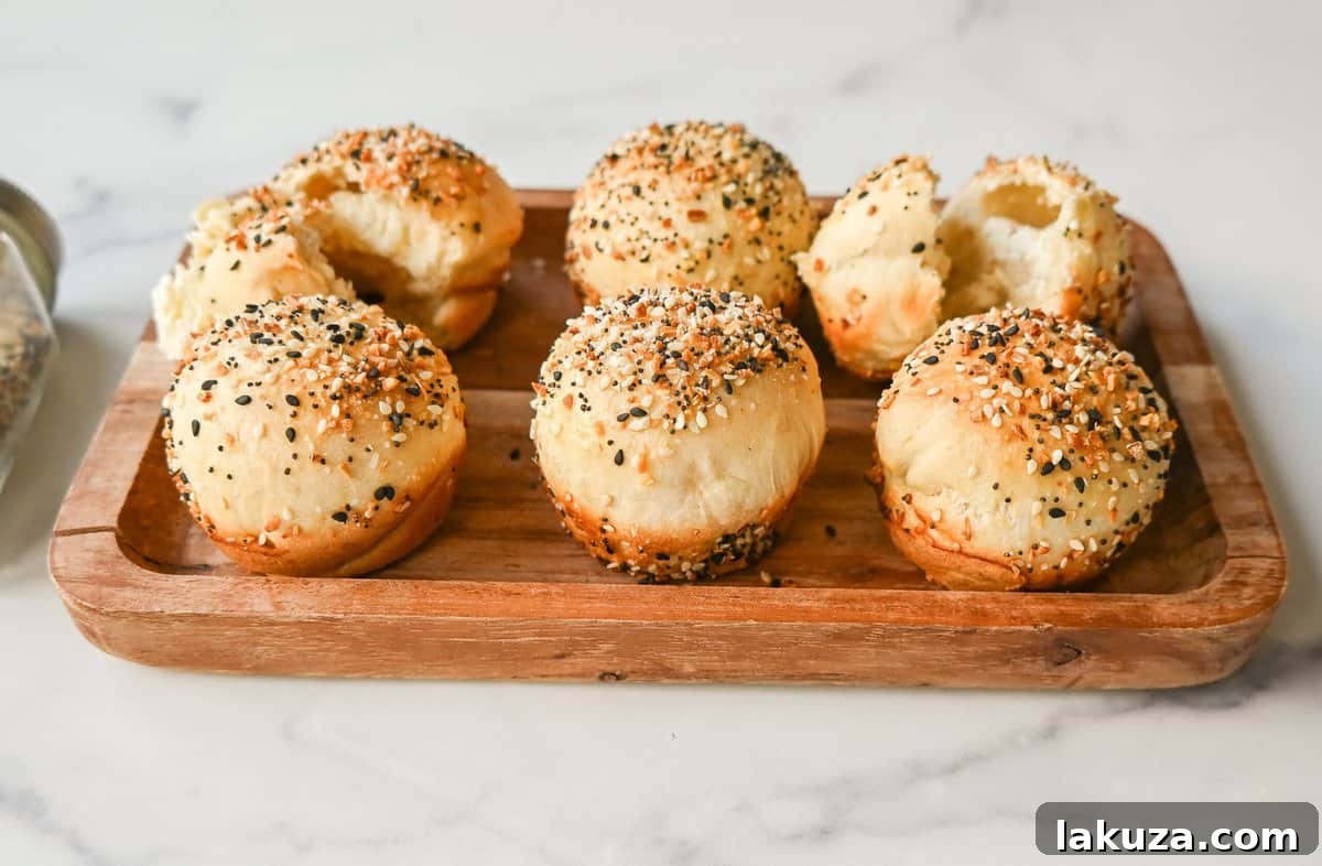 A warm, golden-brown Cream Cheese Filled Everything Bagel Bite held in hand, showing its soft interior and the melted cream cheese peaking through, ready to be eaten.