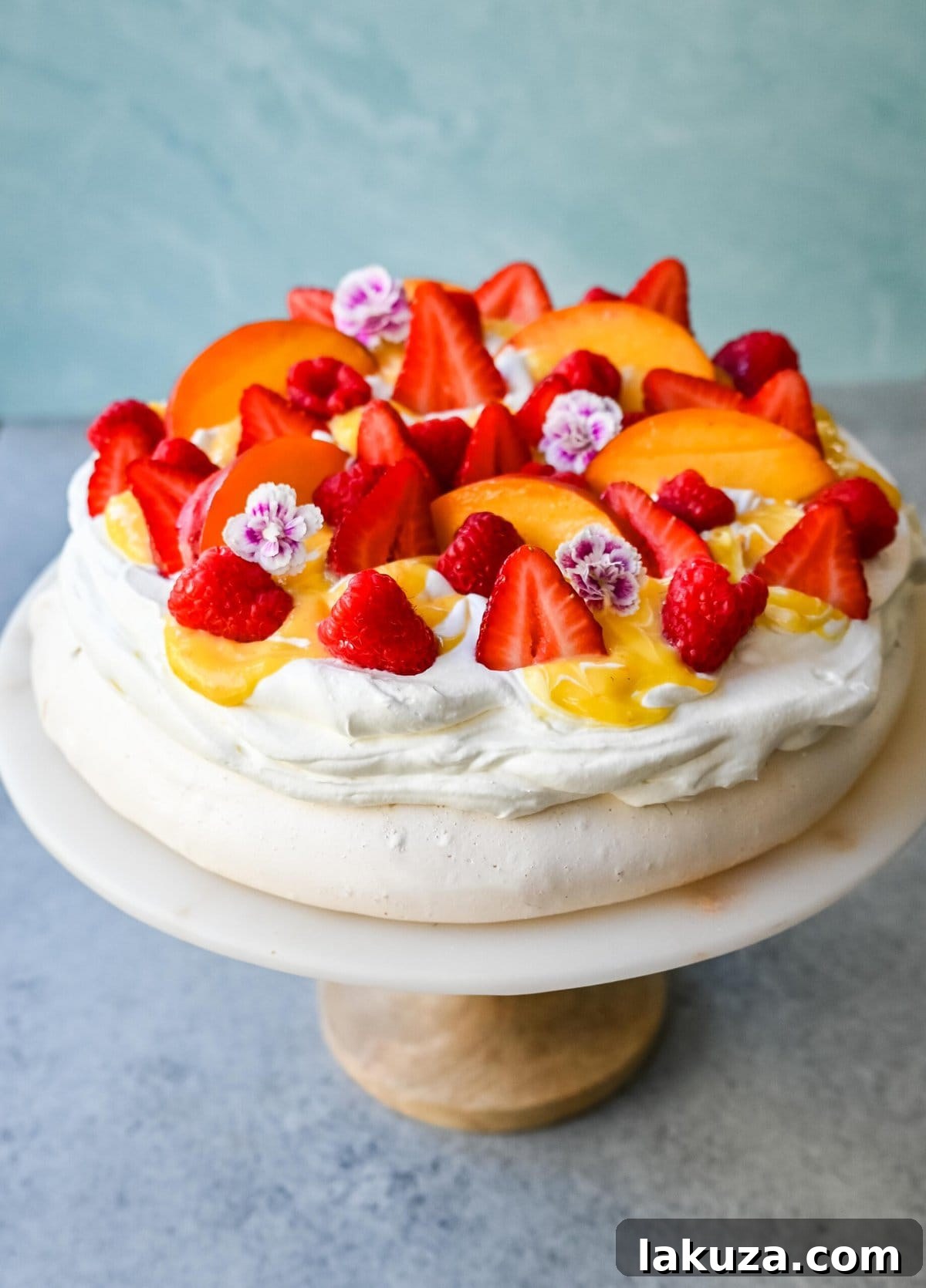 Close-up of a homemade Pavlova, highlighting its crisp exterior and soft, cloud-like texture, adorned with cream and fruit.