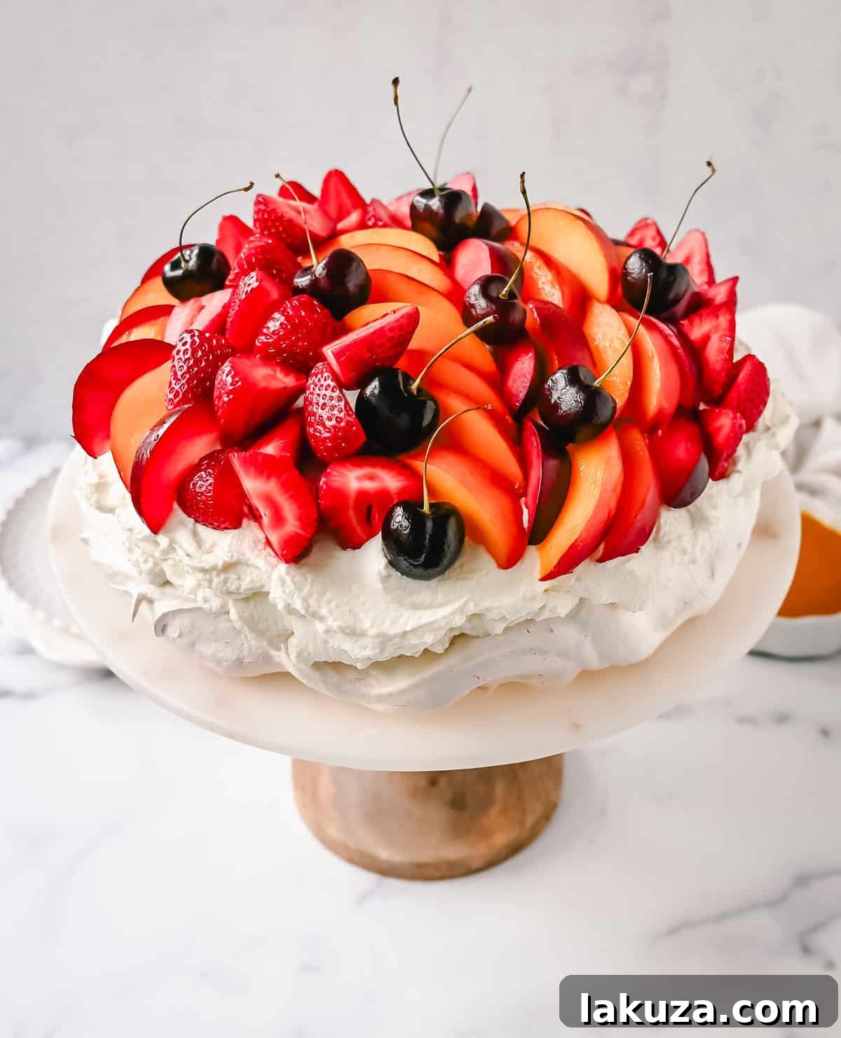 Various fresh fruits like strawberries, raspberries, and kiwi, perfectly complementing a Pavlova.