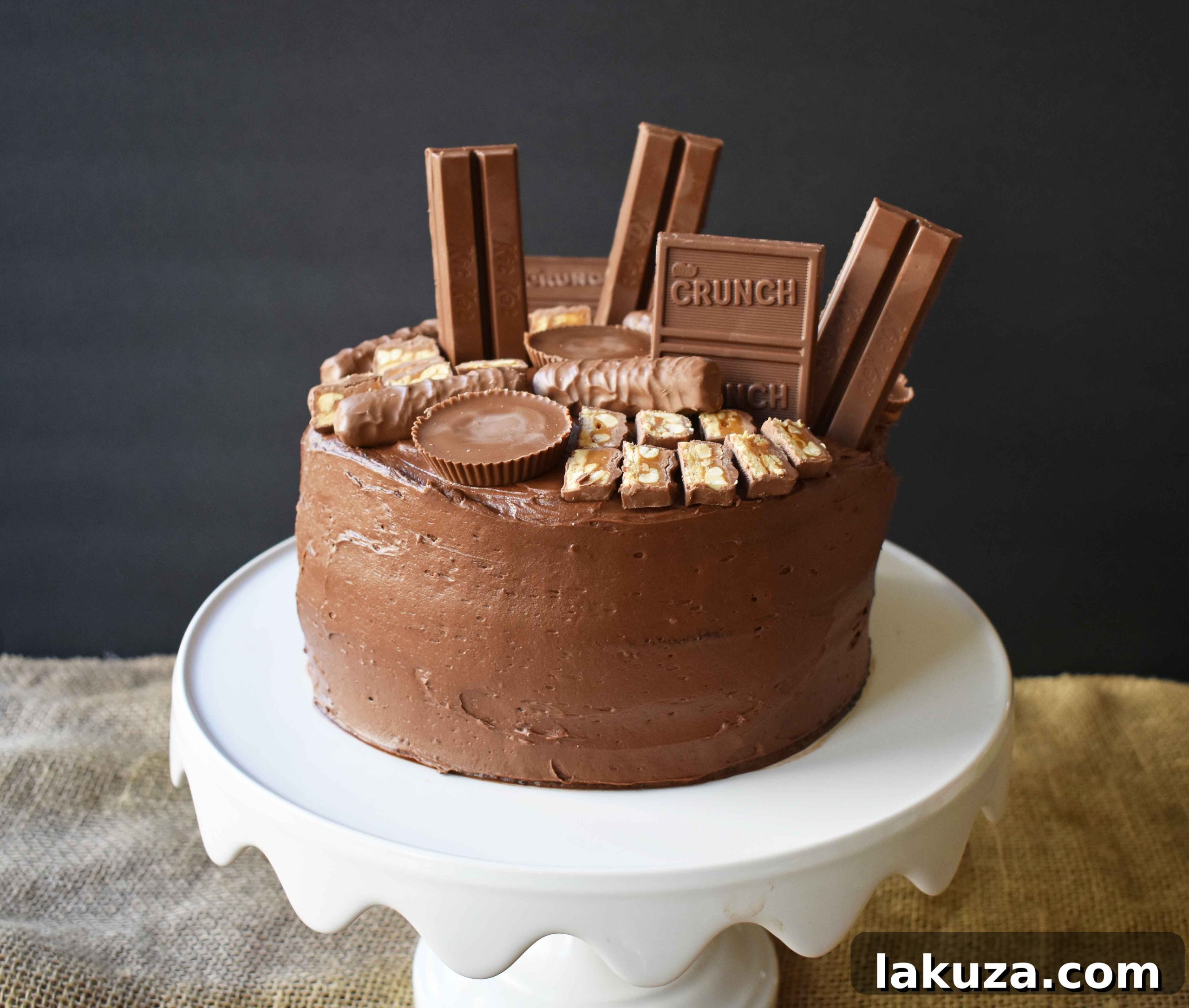 The perfect slice of Chocolate Candy Bar Cake, demonstrating the moist chocolate cake layers, generous chocolate buttercream, and a cross-section of delicious candy bar toppings. A true chocolate lover's dream dessert, ready to be enjoyed.