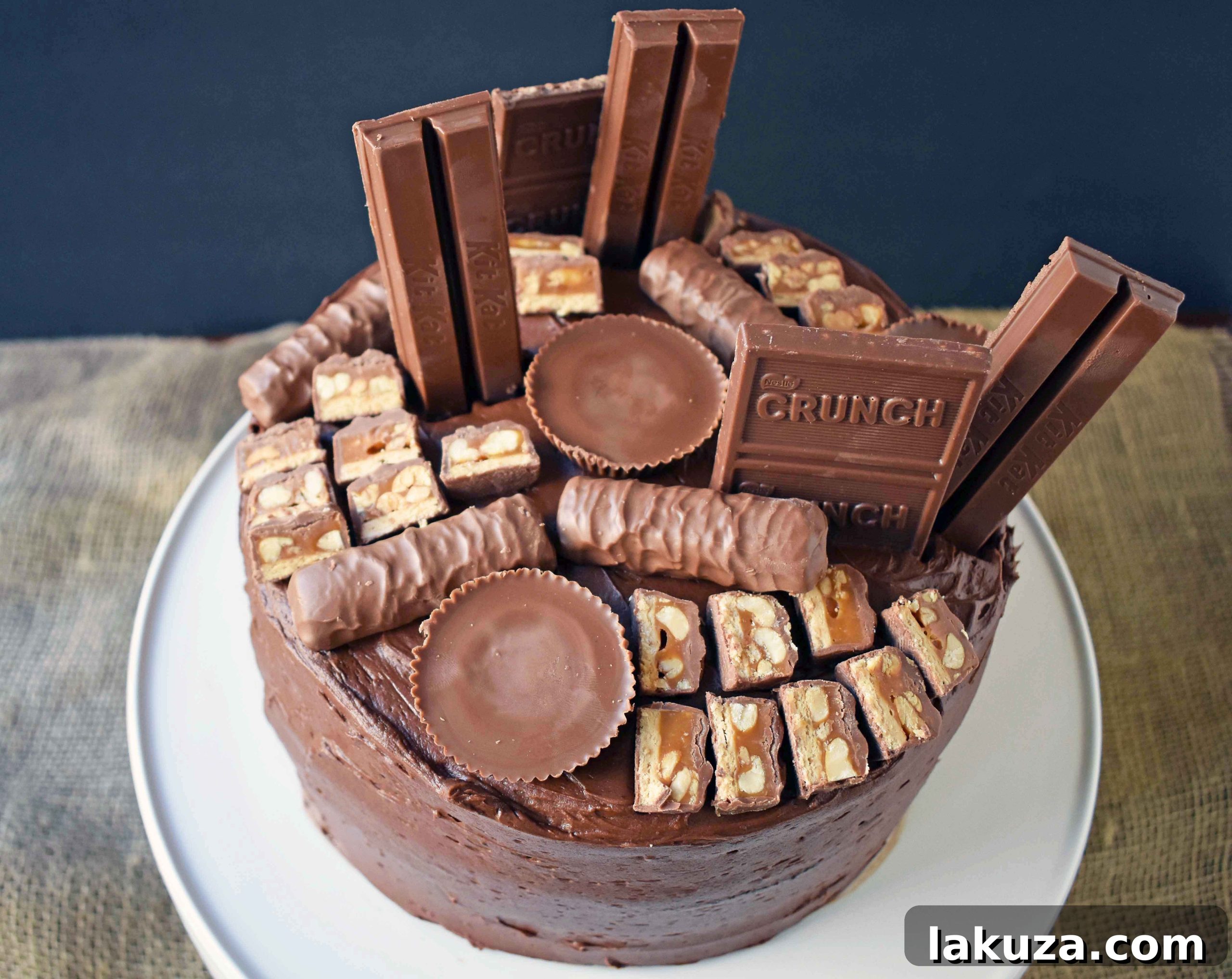 A stunning shot of the Chocolate Candy Bar Cake, showcasing its beautifully even layers, generously applied chocolate buttercream, and a tempting array of chocolate candy bars. This dessert is designed to impress and delight every chocolate lover.