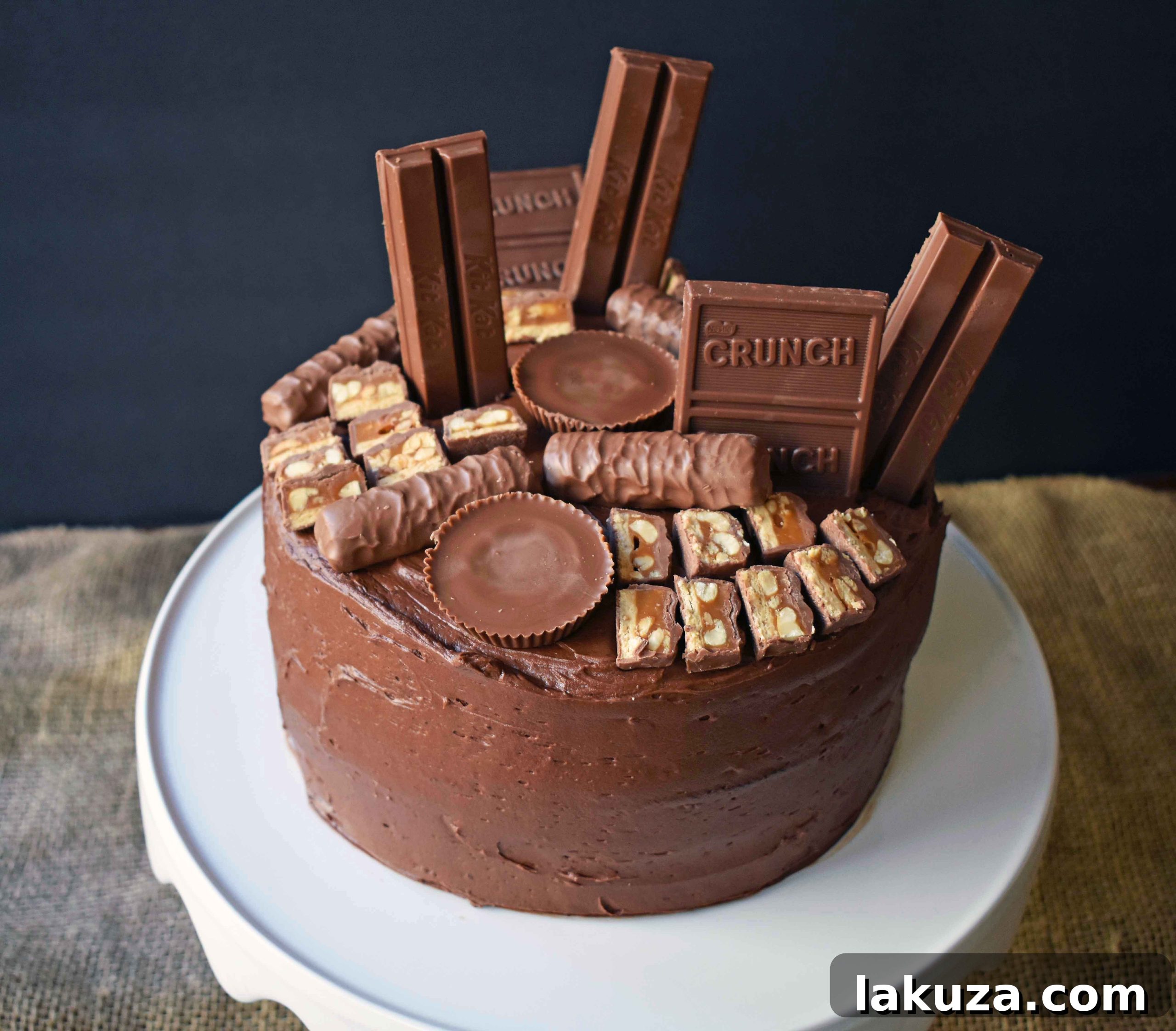 A close-up of the Chocolate Candy Bar Cake, highlighting the vibrant assortment of candy bars like Snickers, Reese's, Kit Kat, and Twix, nestled in the rich chocolate buttercream. This festive cake is a showstopper for any occasion.