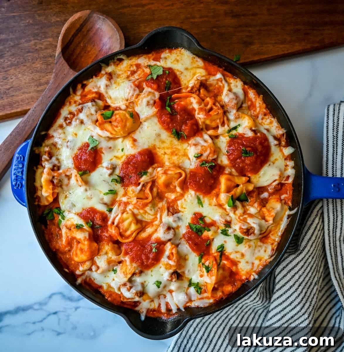 Pillowy Tortellini with Robust Sausage Ragu 5 Delicious serving of Cheese Tortellini with Sausage Ragu in a white bowl, garnished with fresh basil, ready to eat.