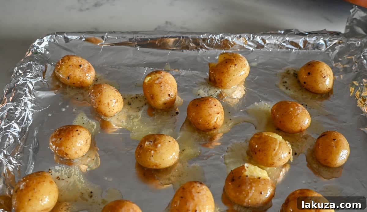 Loaded Bacon Cheddar Smashed Potatoes perfectly smashed on baking sheet.