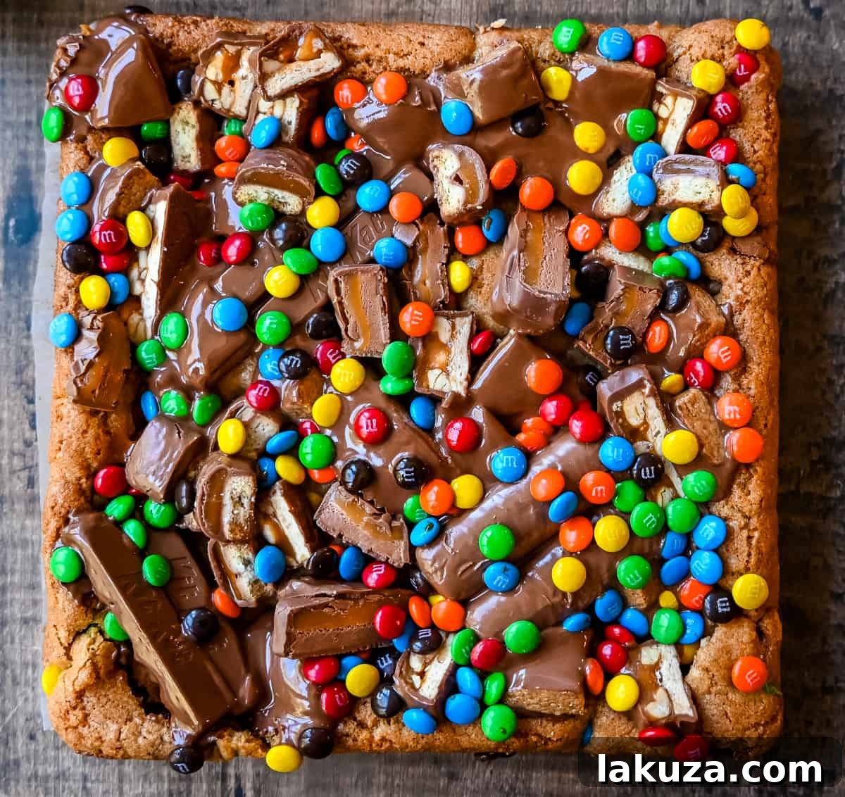 Ultimate Candy Bar Blondies 3 Candy Bar Cookie Bars. An ooey gooey cookie bar topped with an assortment of candy bars. The perfect candy bar blondie dessert to make with Halloween candy.