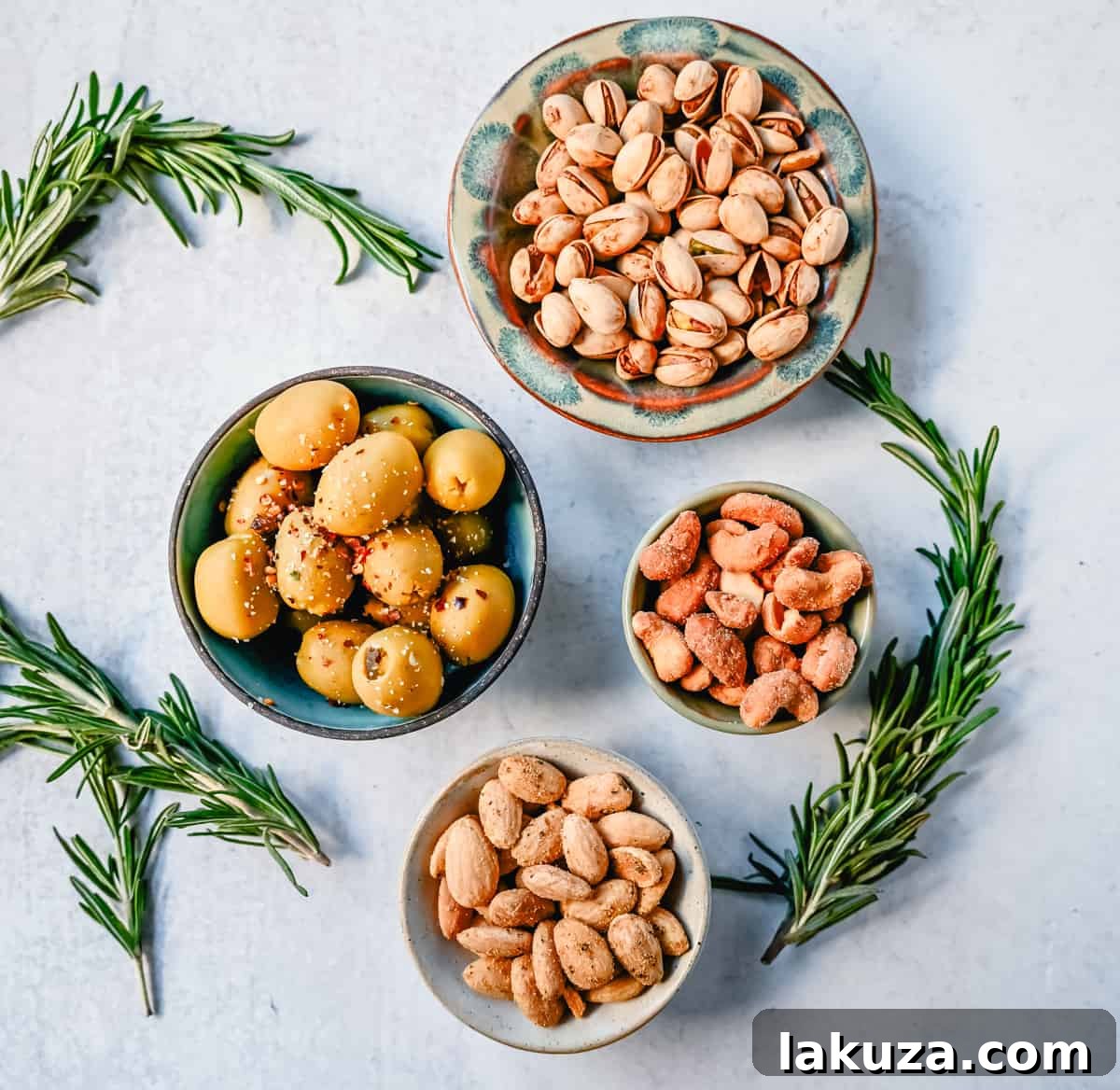 Creating a Showstopping Charcuterie Board 12 A small bowl overflowing with various nuts, including cashews and almonds, and green olives, ready to be added as crunchy and savory accents to a charcuterie board.