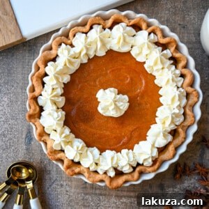 The ultimate Southern Sweet Potato Pie recipe, featuring a creamy, spiced brown sugar filling and a buttery crust, crowned with fresh whipped cream.