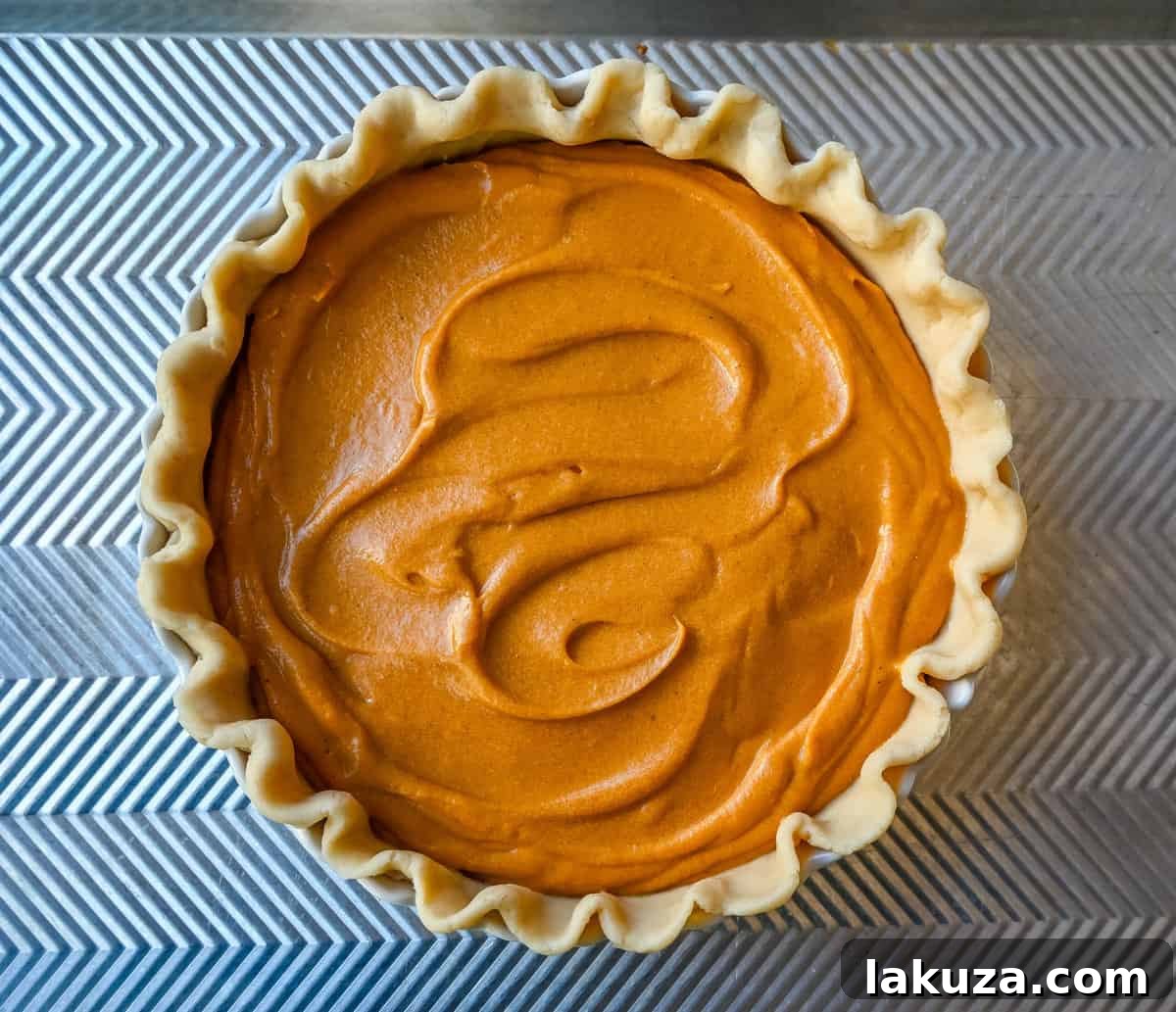 Creamy sweet potato pie filling ready to be poured into a blind-baked pie crust.