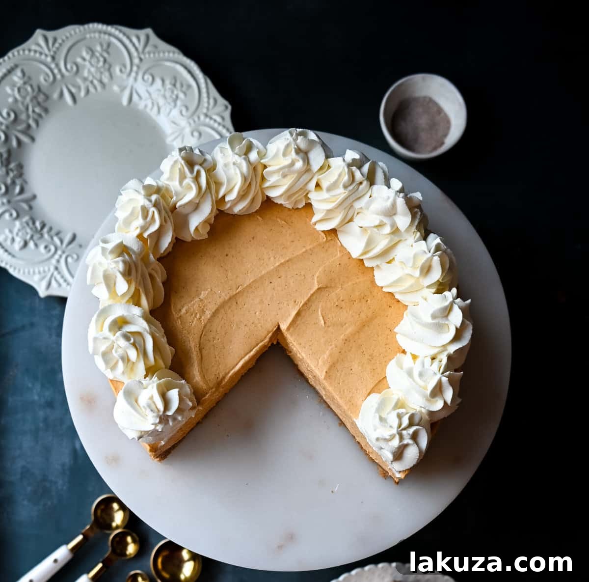 Effortless Pumpkin Cheesecake 7 Fully assembled No-Bake Pumpkin Cheesecake with a generous layer of whipped cream and a sprinkle of cinnamon, ready for serving.