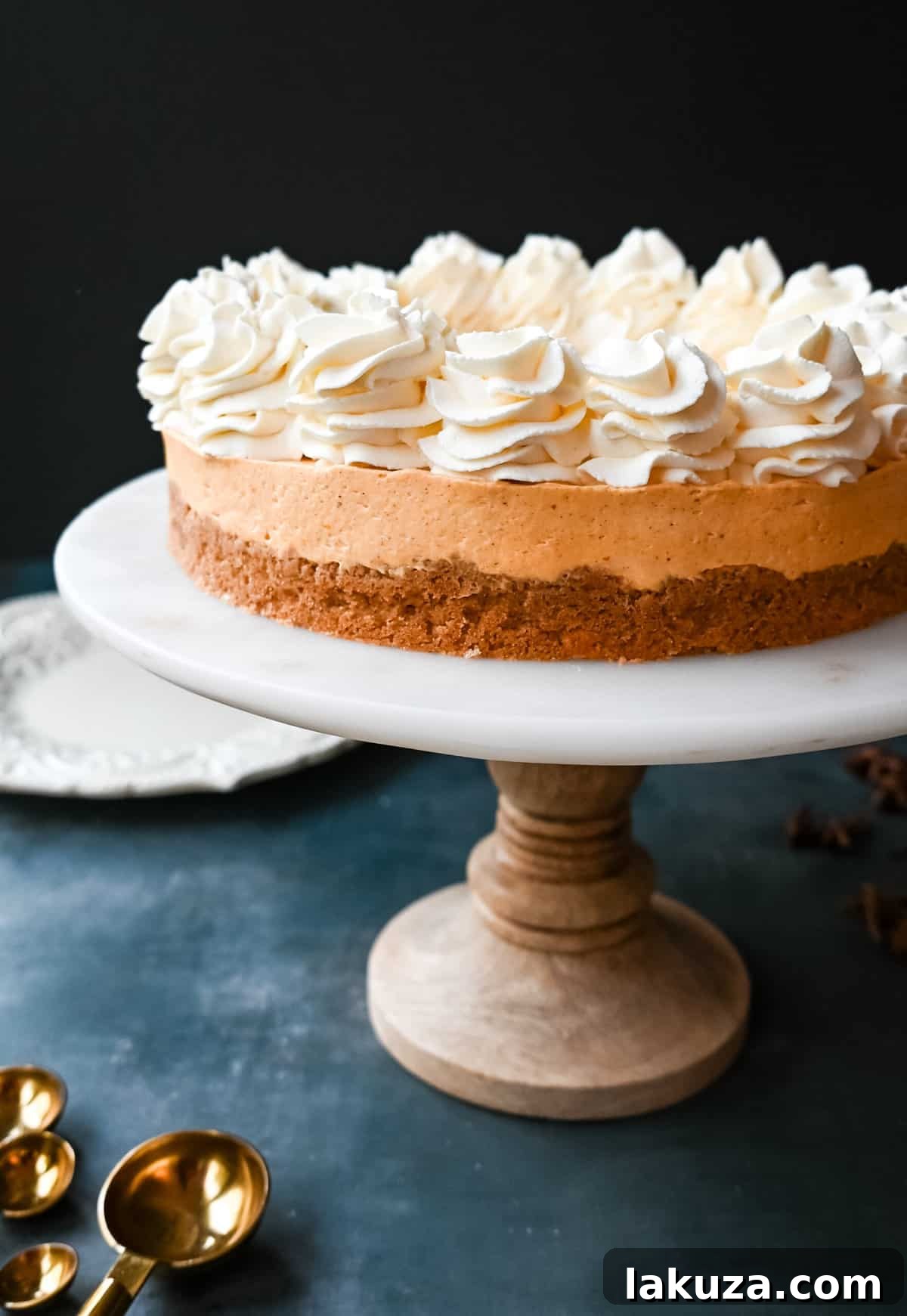 Effortless Pumpkin Cheesecake 9 A festive slice of No-Bake Pumpkin Cheesecake on a plate, garnished with whipped cream and a sprinkle of cinnamon, ready to be enjoyed.