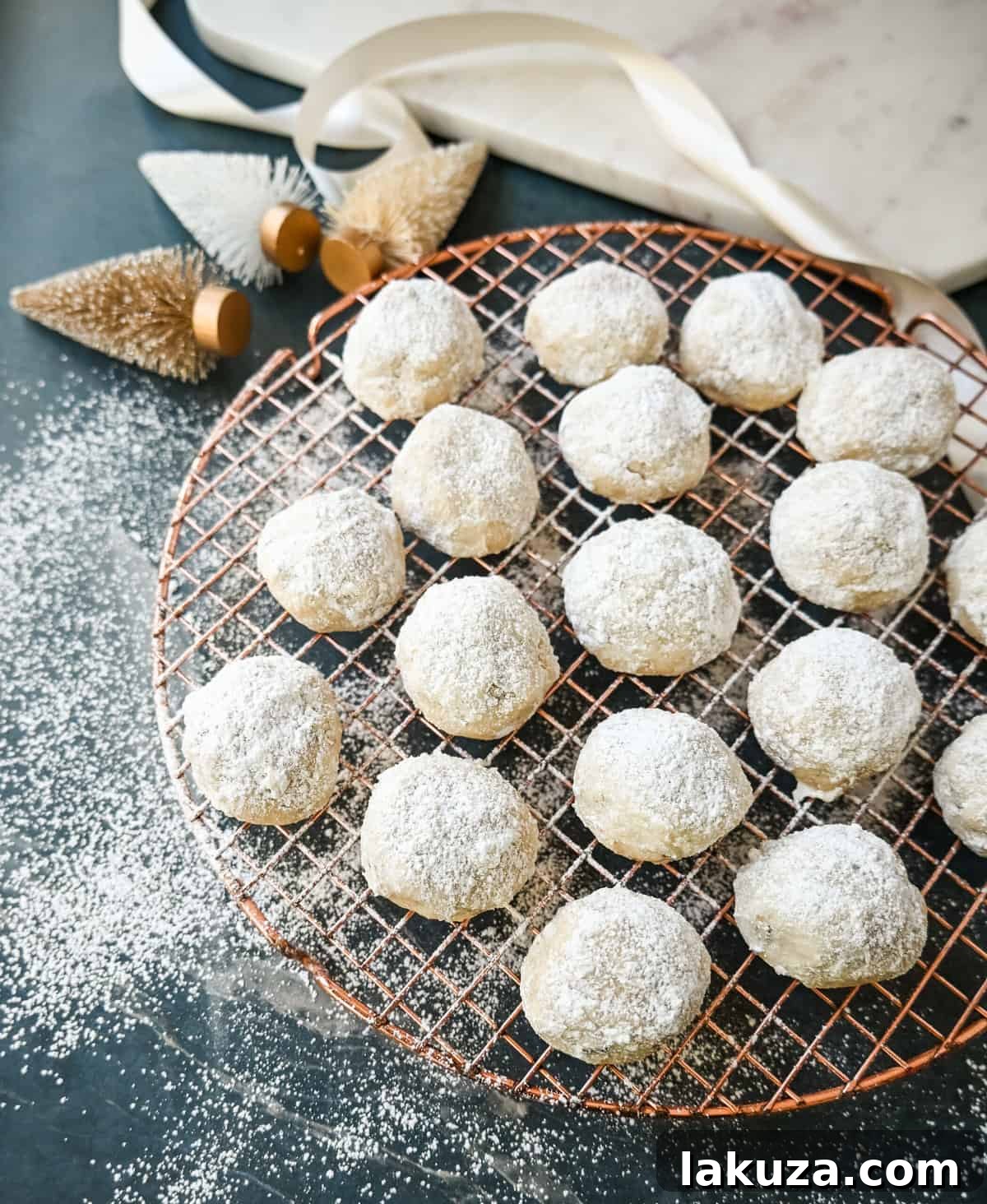 Elegant Pecan Snowball Cookies 6 Freshly baked Mexican Wedding Cookies (Snowball Cookies) on a wire rack before the second powdered sugar coating.