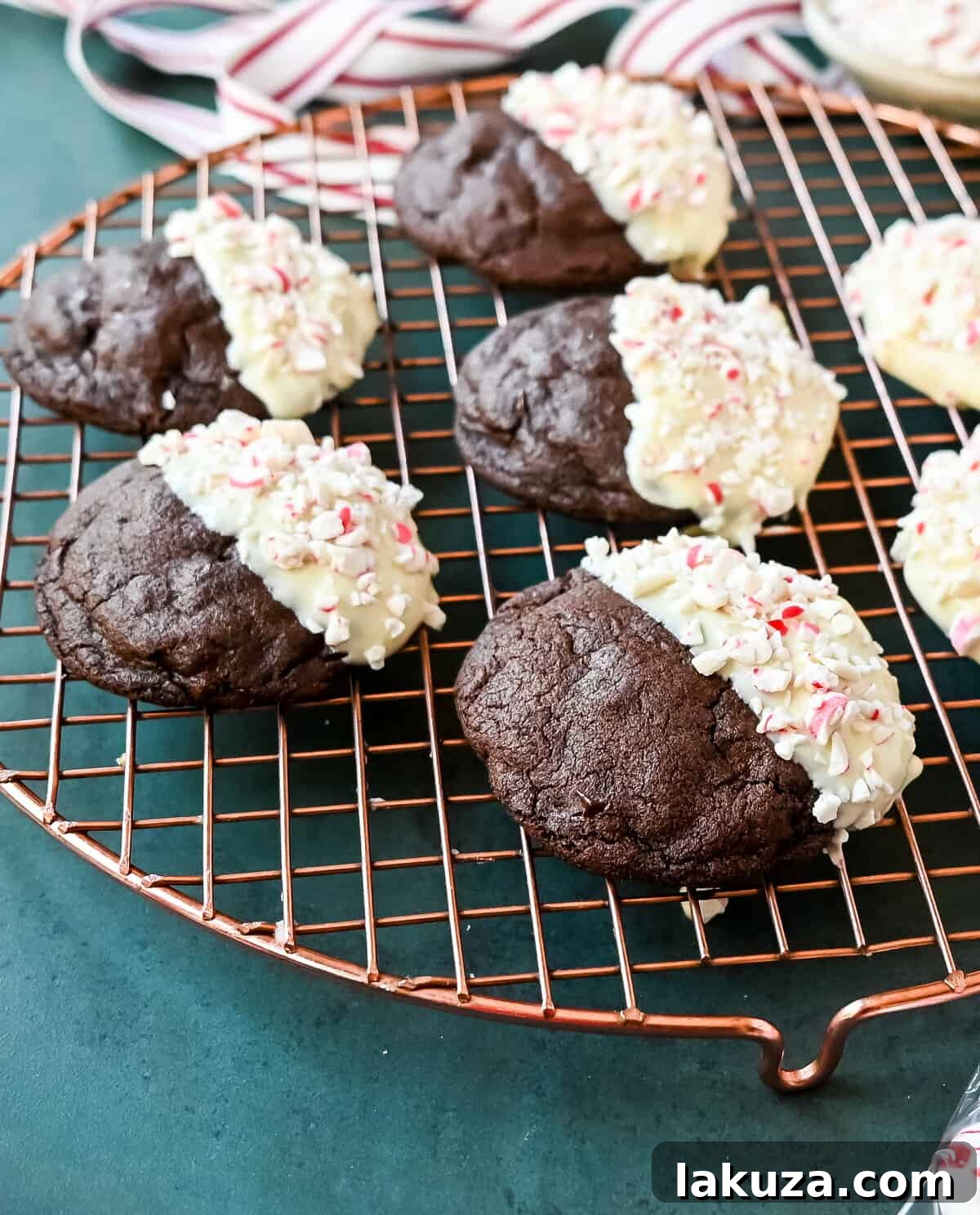 White Chocolate Dipped Peppermint Chocolate Cookies. The Double Chocolate Peppermint Cookies are soft baked, rich double chocolate brownie cookies dipped in white chocolate and covered with peppermint candy canes. The perfect Christmas holiday cookie recipe.